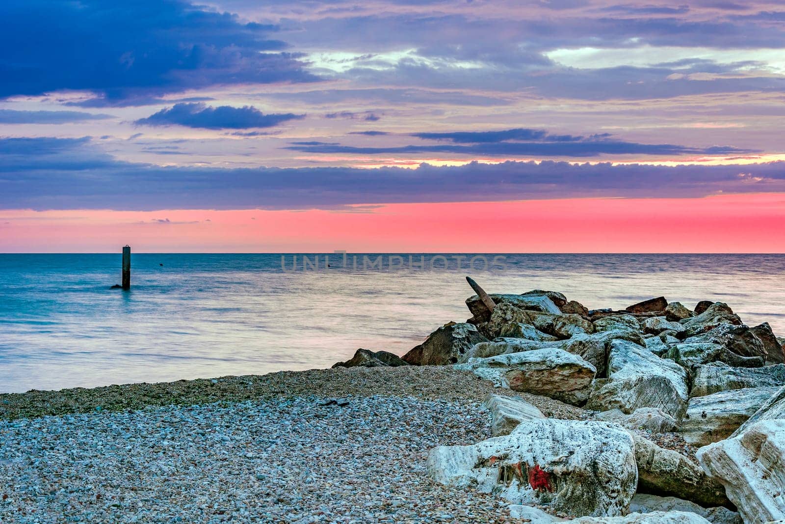 stony coastline with a cloudy  sunrise