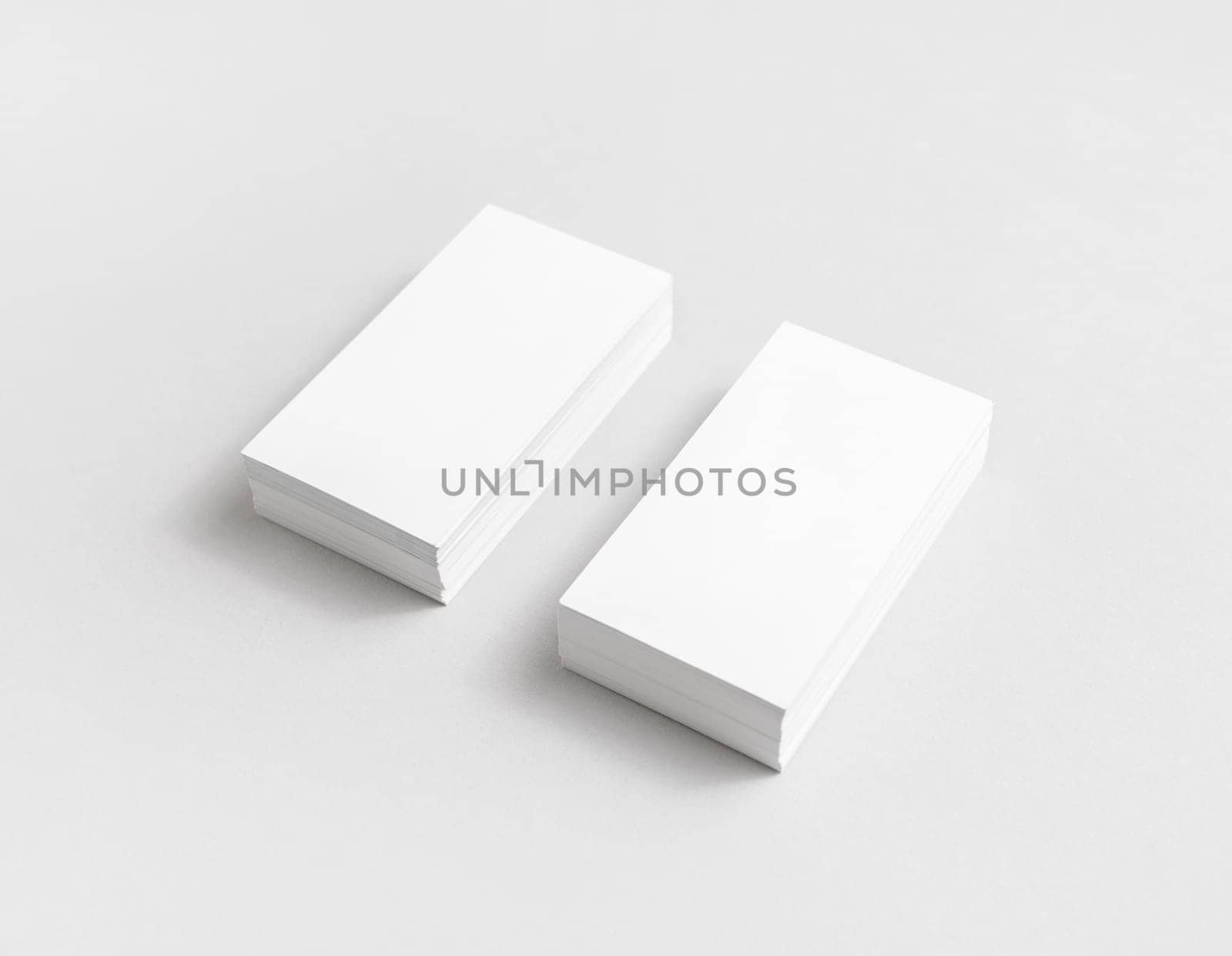 Photo of blank white paper business cards with soft shadows. Mock up for branding identity for designers.