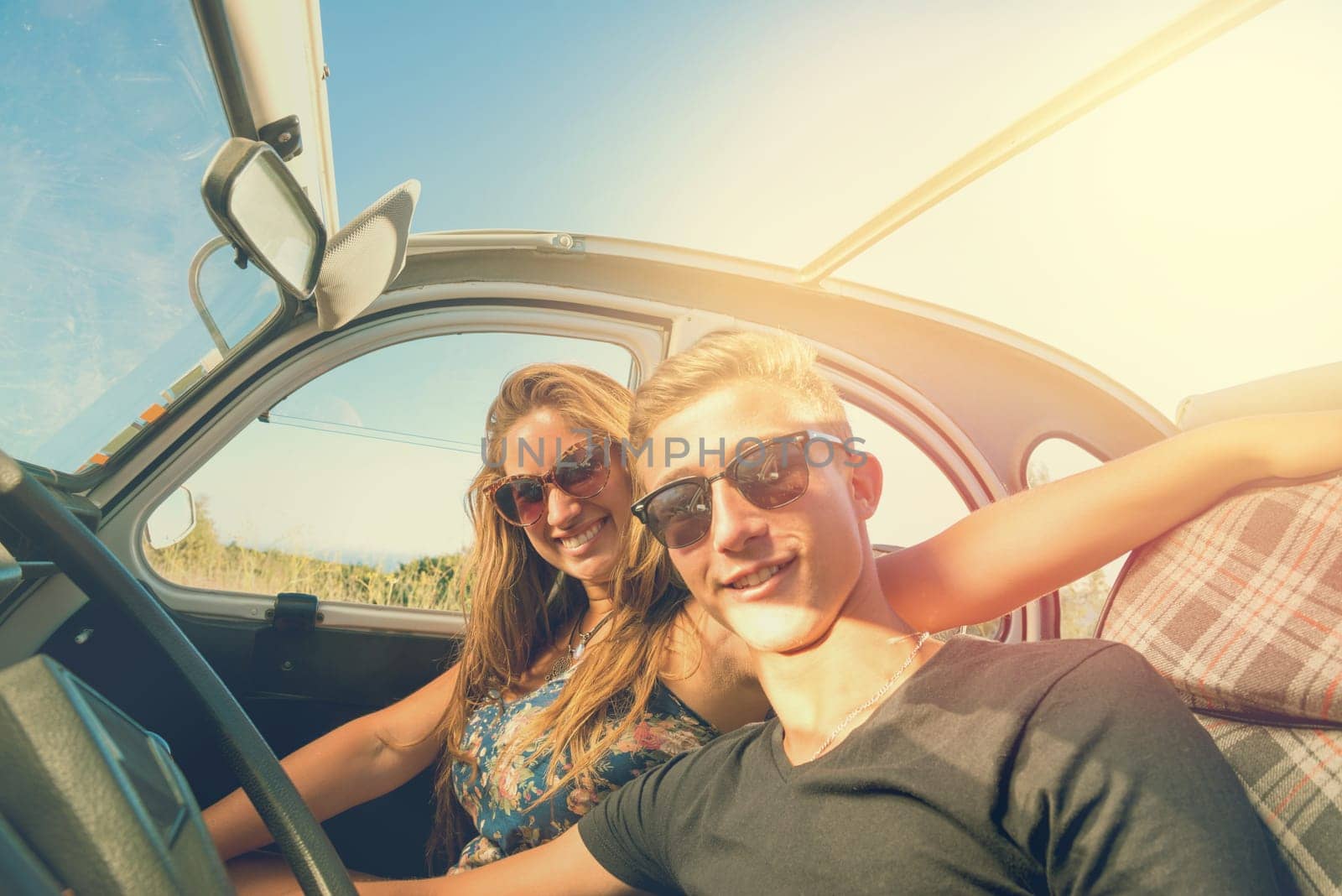 Young couple in a retro car at sunset, retro style.