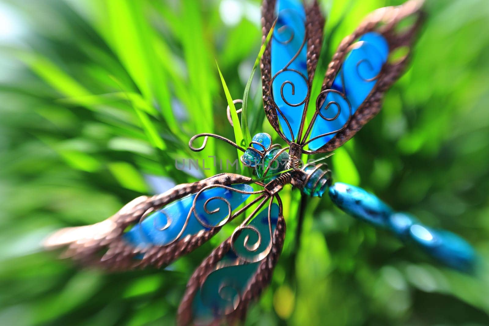 Artificial decorative butterfly in a plant, creative blur effect