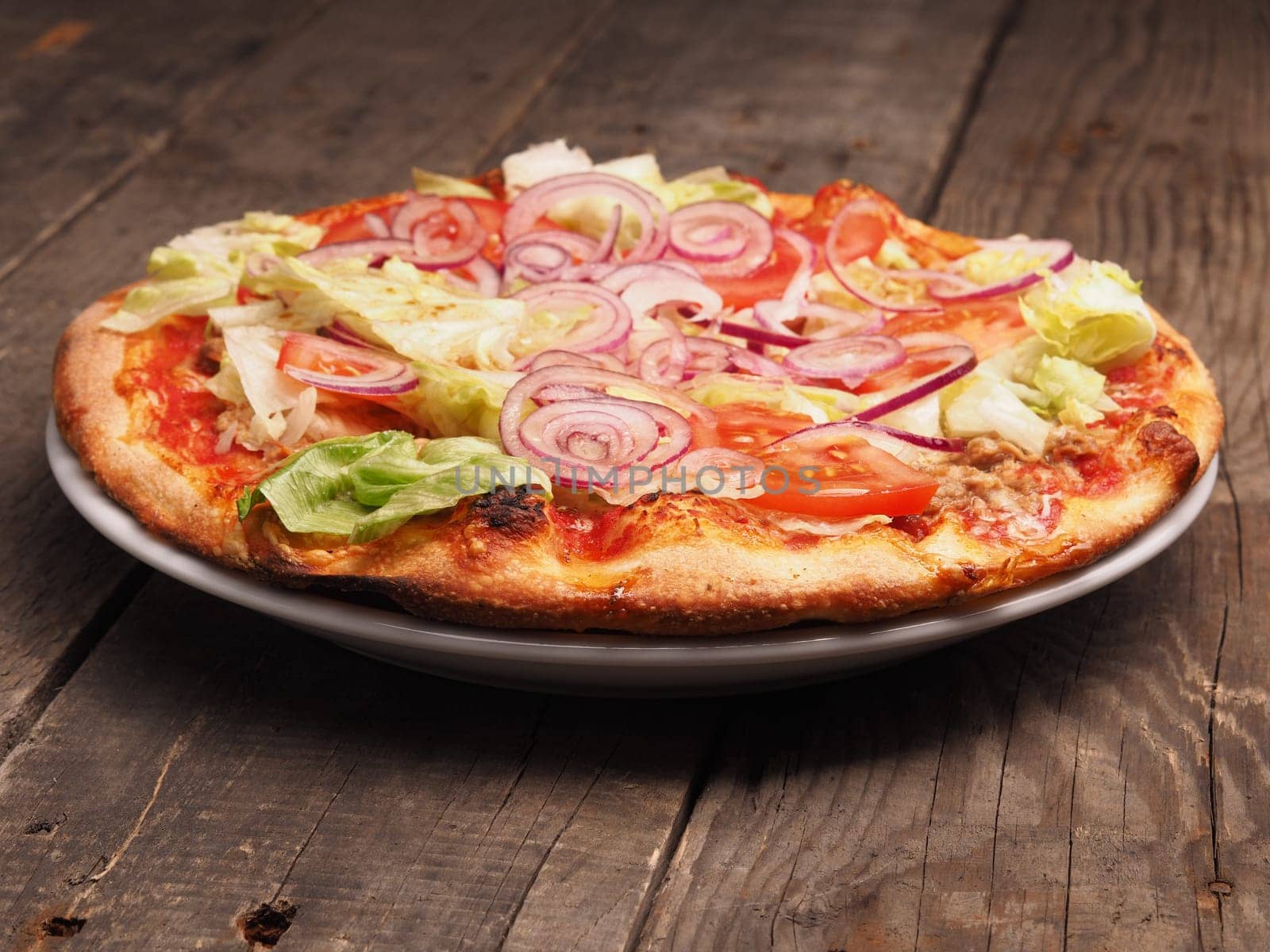 Crispy pizza with tuna, lettuce and fresh tomatoes, traditional Italian food concept