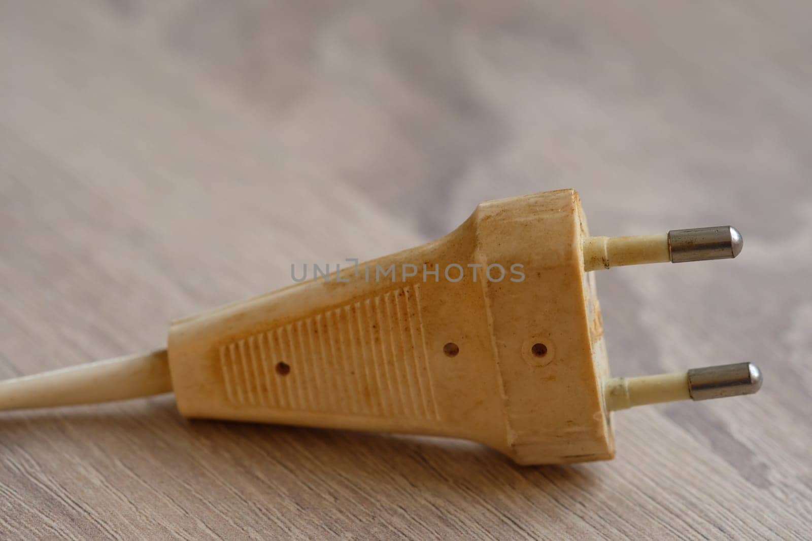 Age dirty beige white Euro plug as a close-up