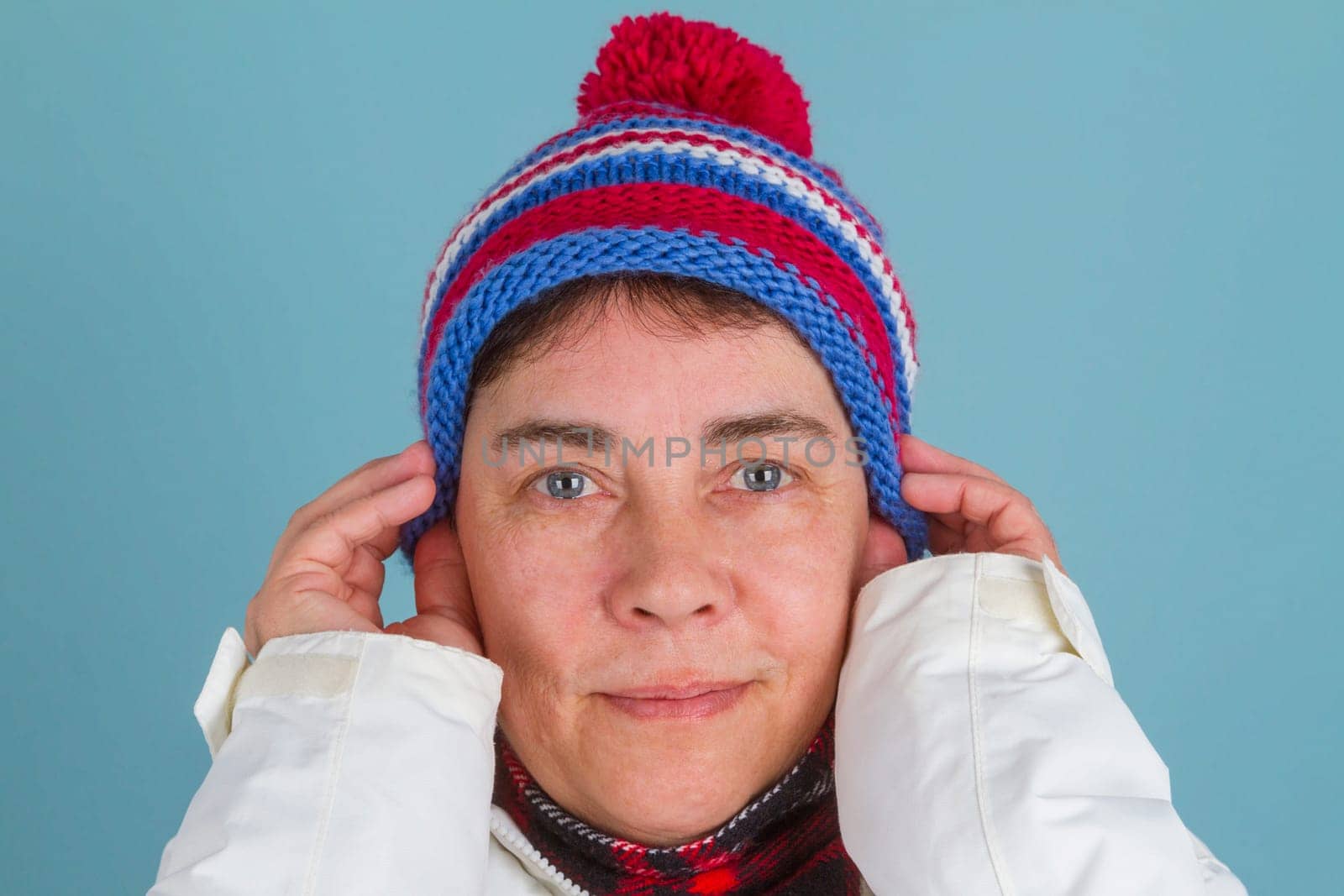 Middle-aged woman in winter clothes on a blue background