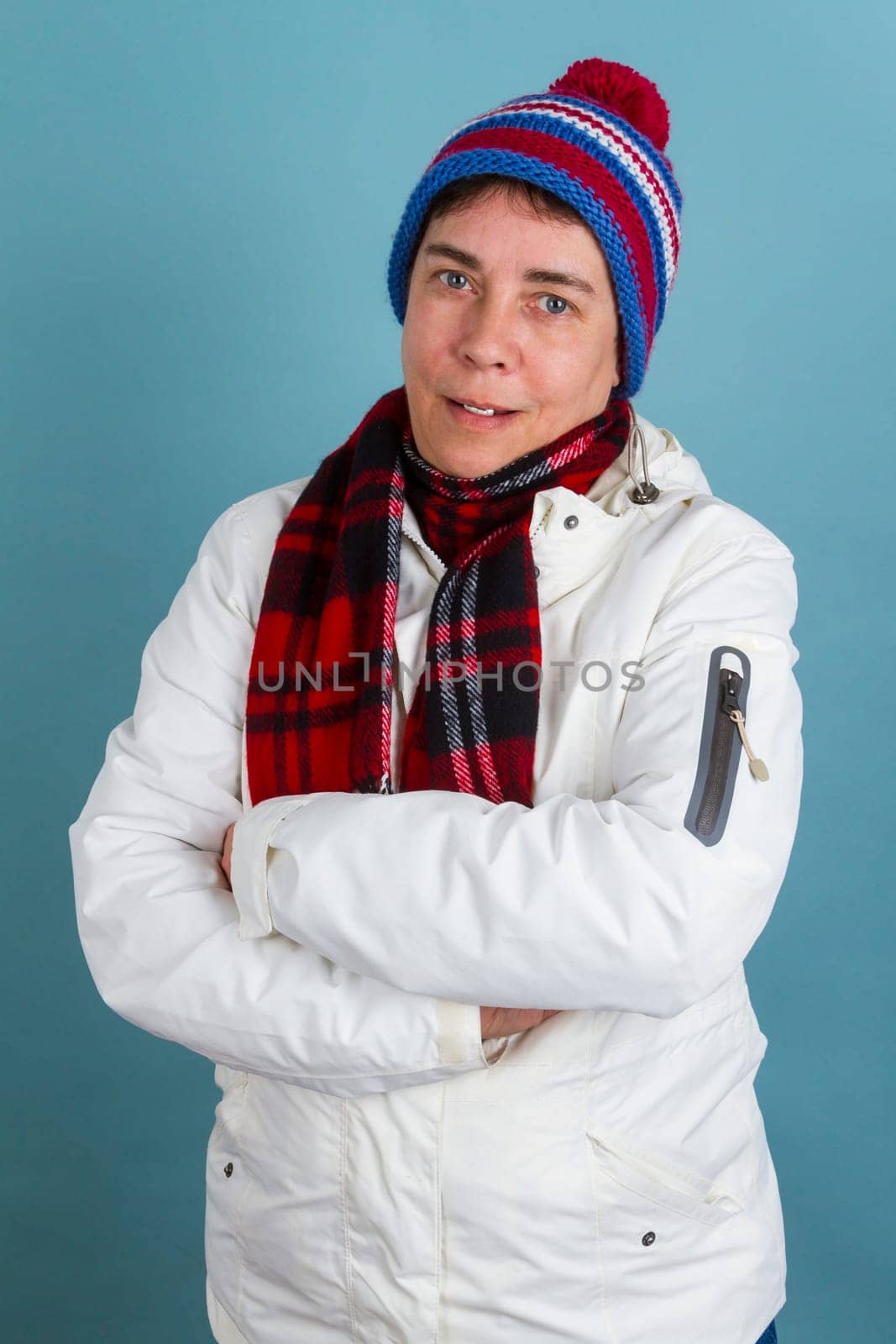 Middle-aged woman in winter clothes on a blue background