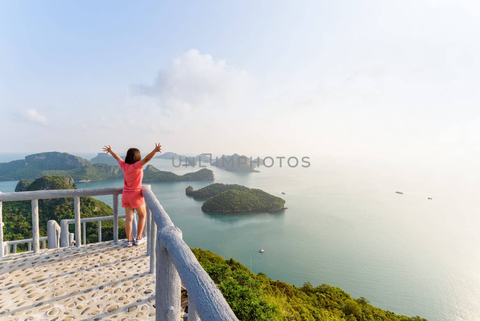 Woman tourist on the balcony is peak view point of Ko Wua Ta Lap island and beautiful nature landscape during sunrise over the sea in Mu Ko Ang Thong National Park, Surat Thani, Thailand