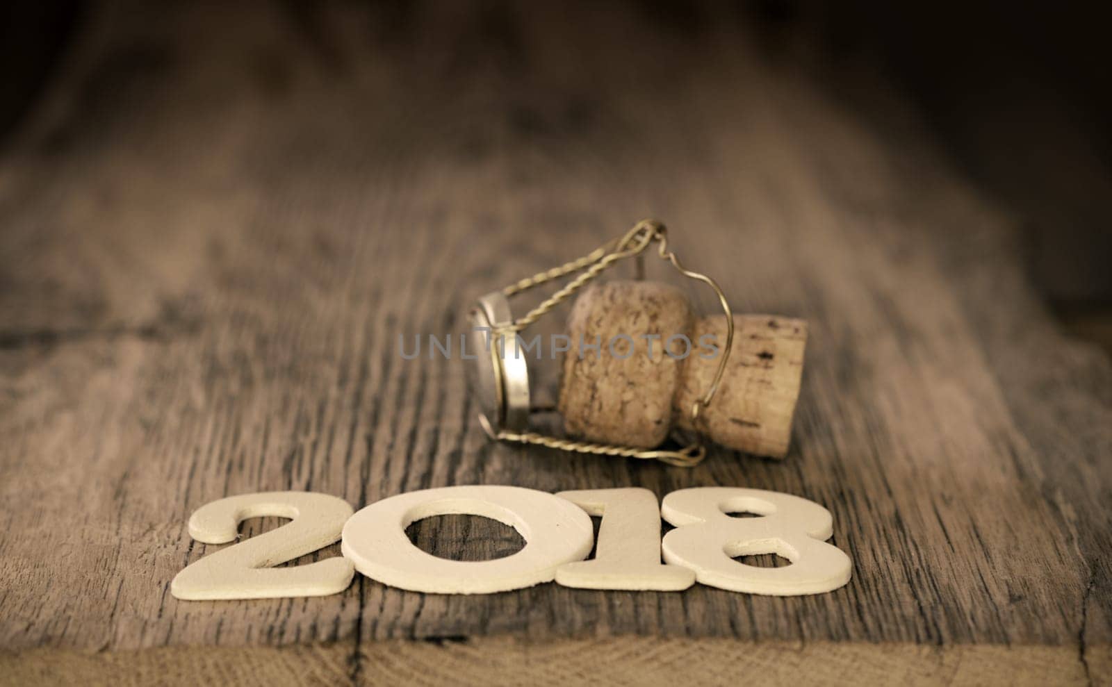New Year 2018 concept with a champagne bottle cork and the number 2018 on a wooden table