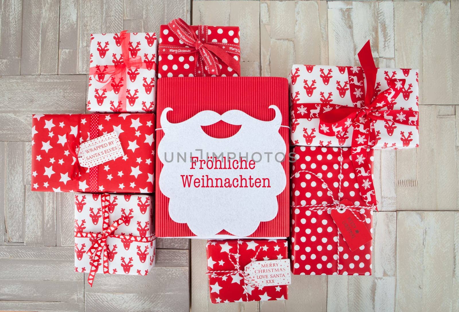 Red and white wrapped gifts for Christmas on wooden background