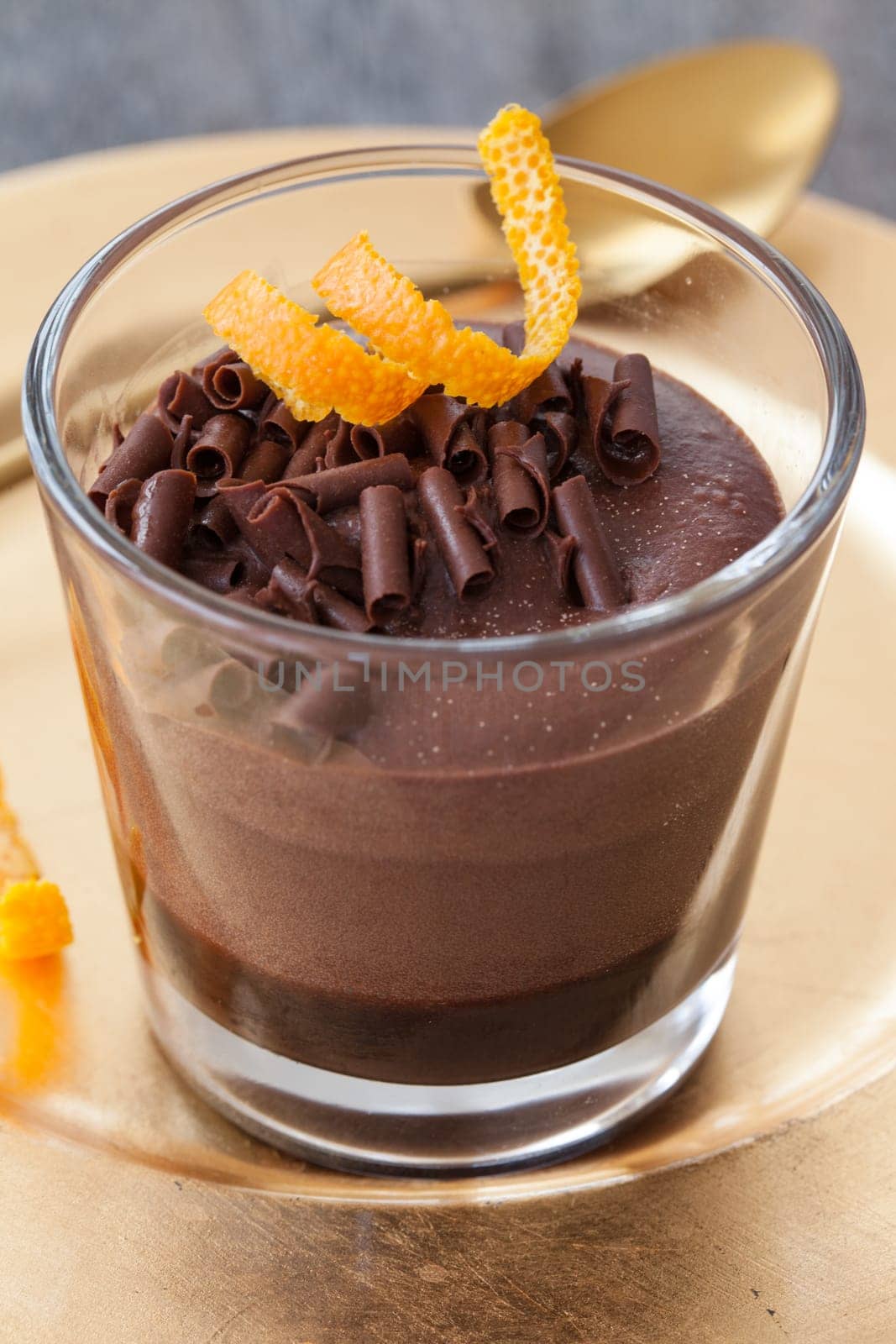 Delicious layer dessert in a glass with chocolate and orange