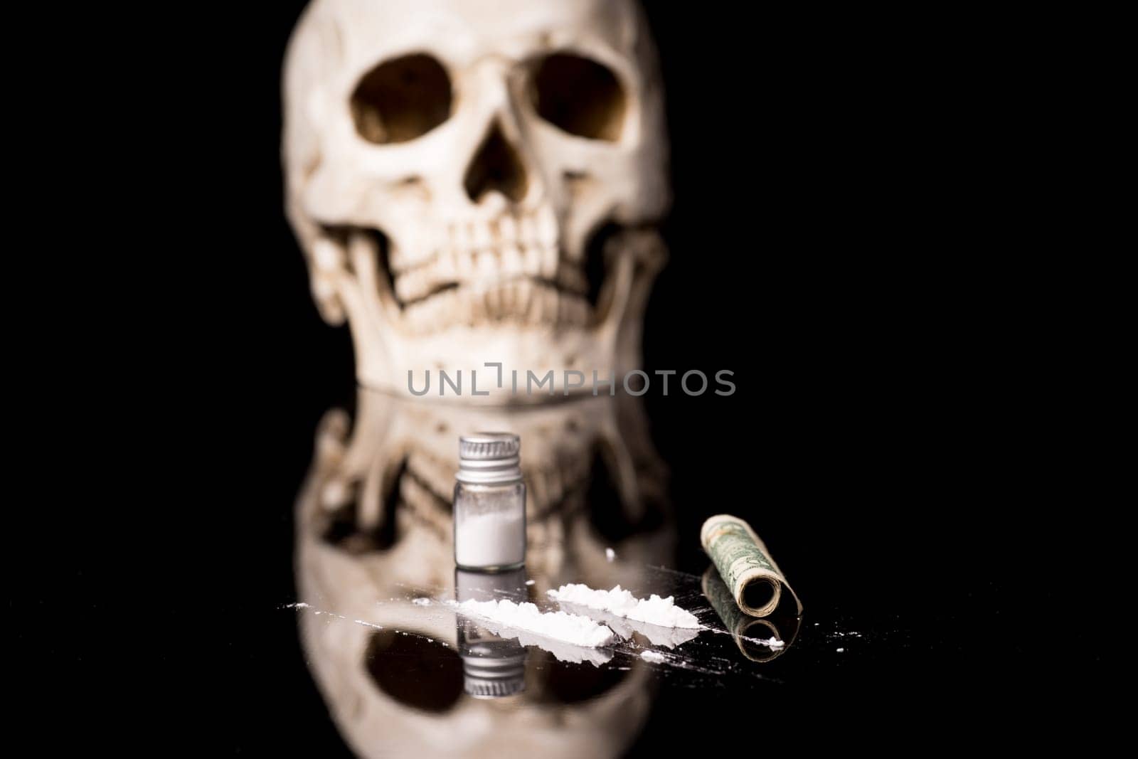cocaine or other illegal drugs that are sniffed by means of a tube and Skull, isolated on black glossy background