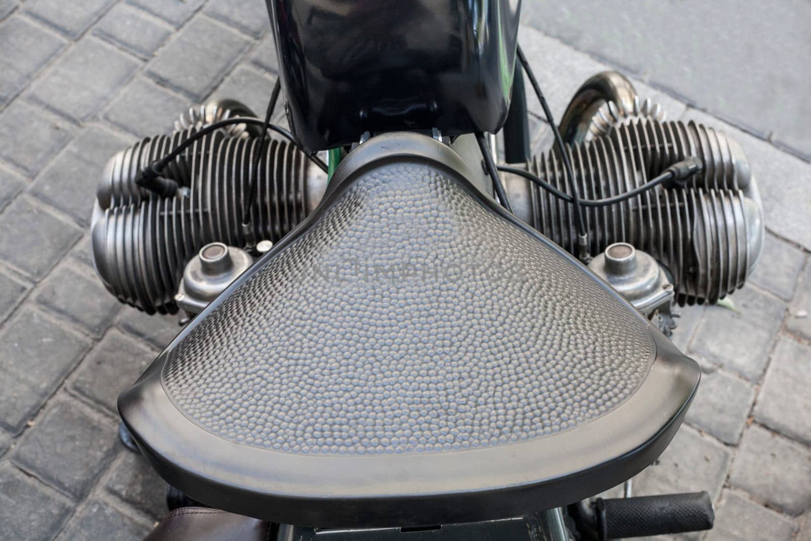 Old motorcycle vintage leather saddle over pavement background