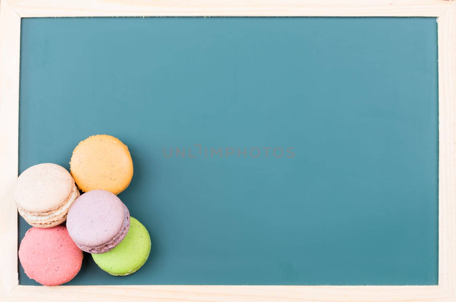 Macarons on a green chalkboard close up