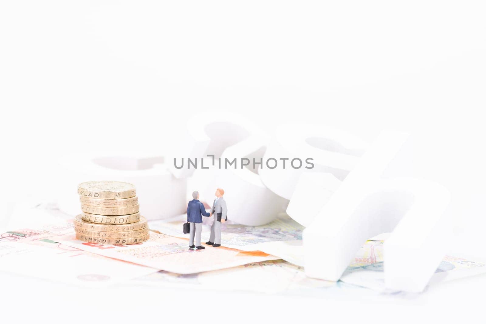 Miniature businessman shaking hands close up