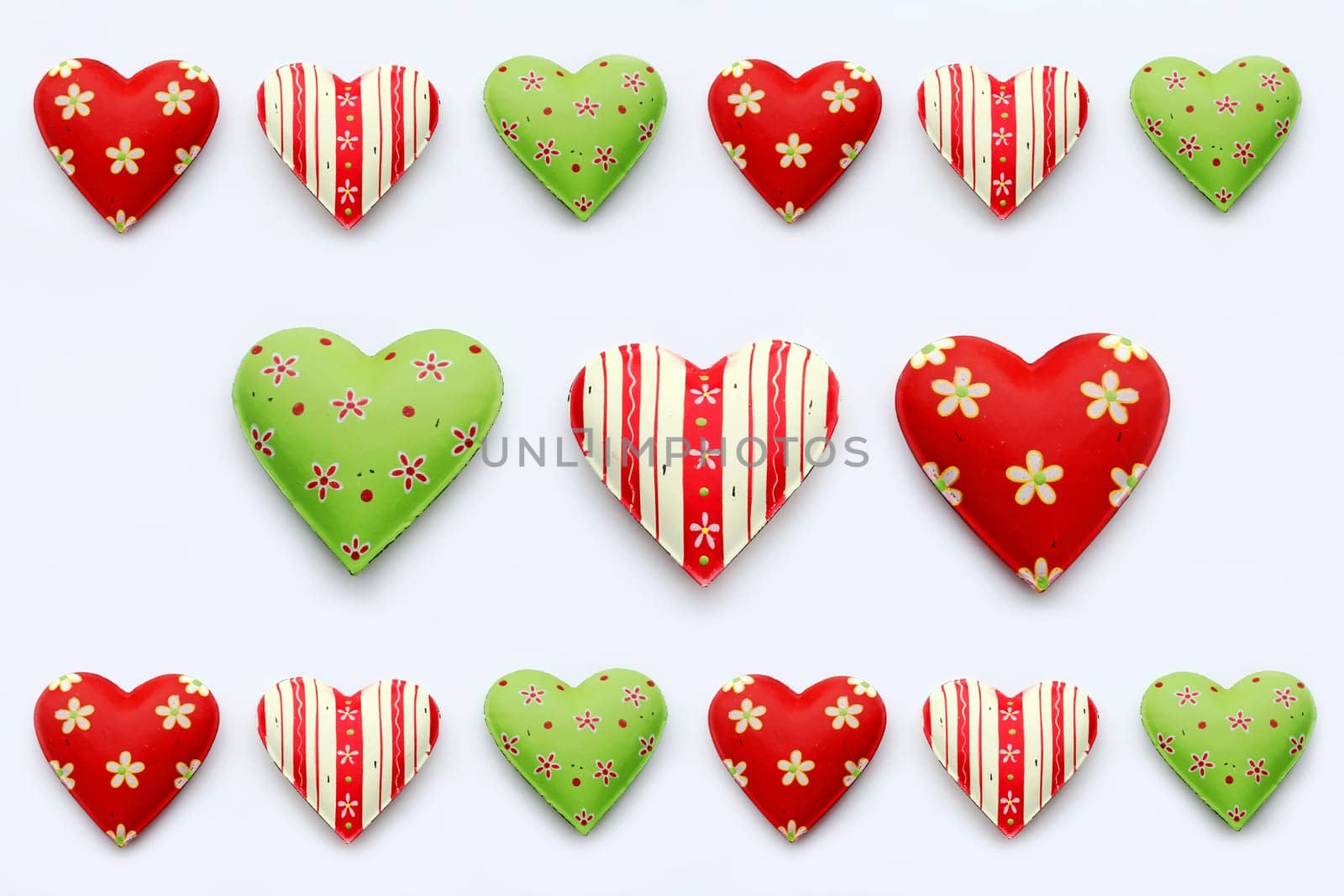 Many colorful hearts on a white background. Red-green metal hearts