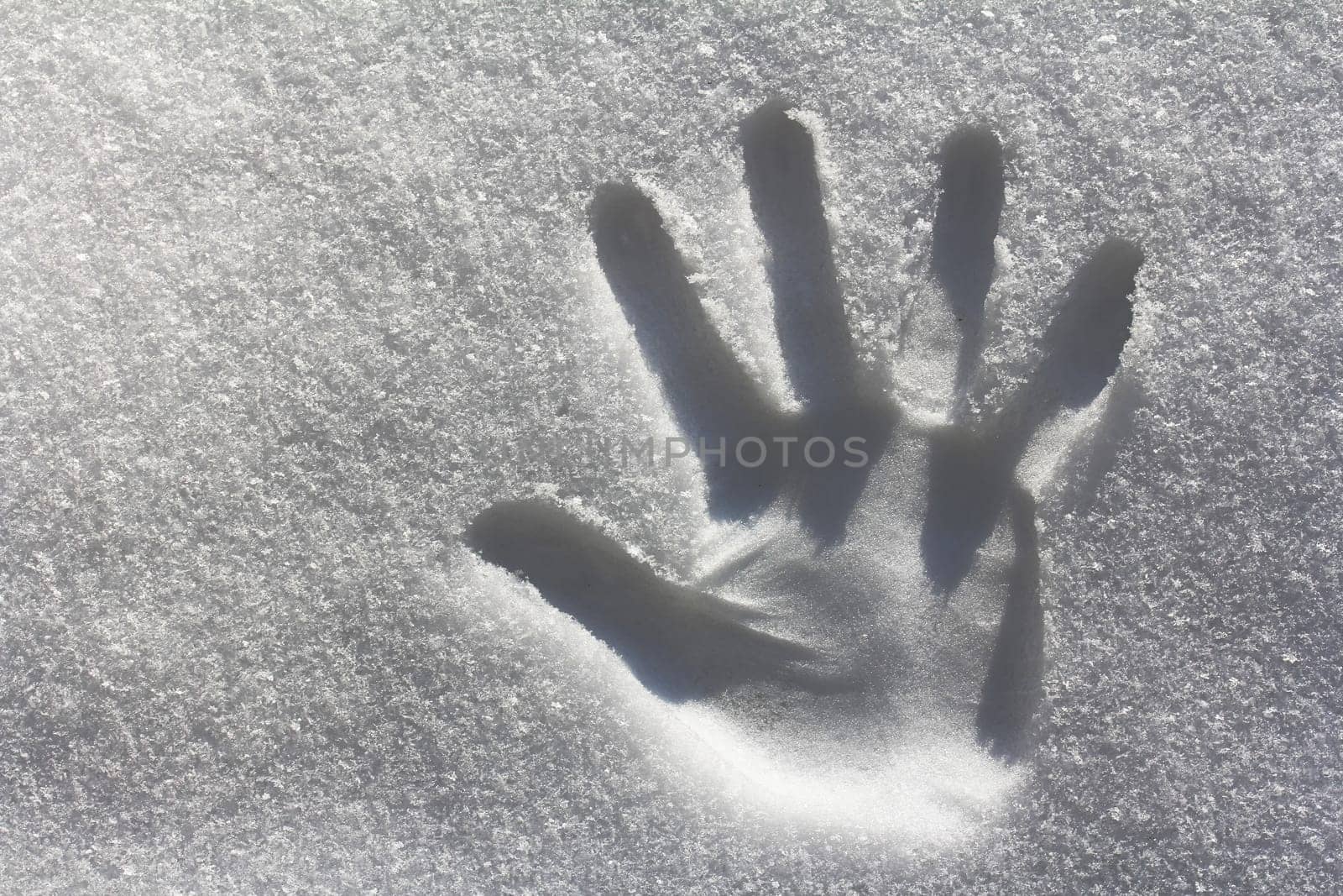 A handprint in the snow. Imprint from one hand in the cold snow