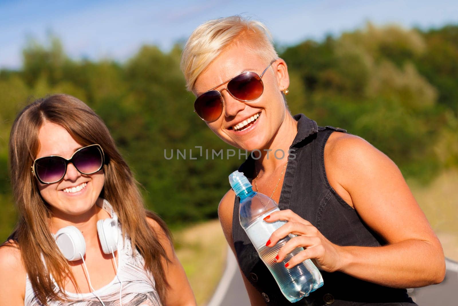 Two young fitness girls outdoor portrait in summer time