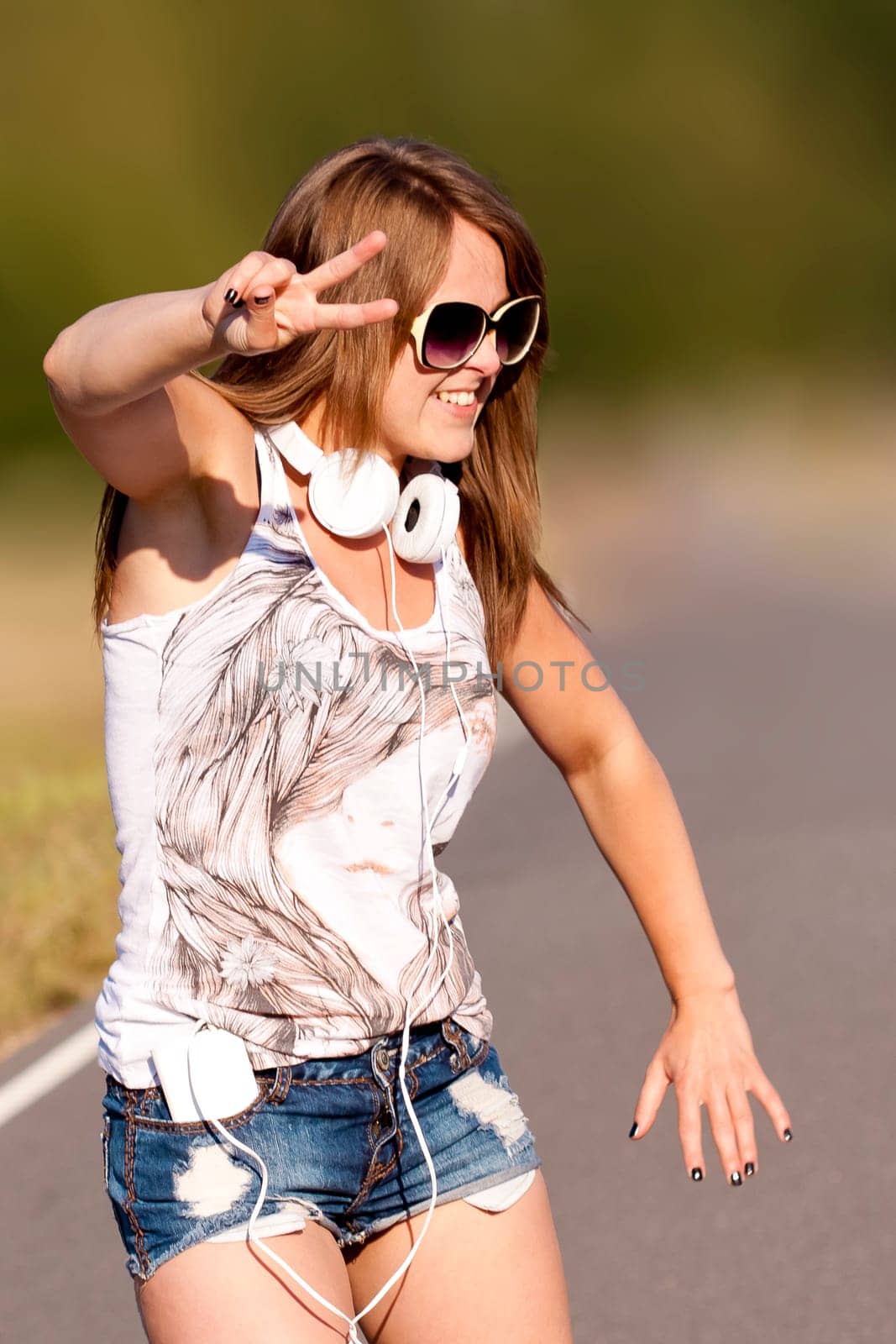 A young pretty and happy girl dancing outdoor in the summer time