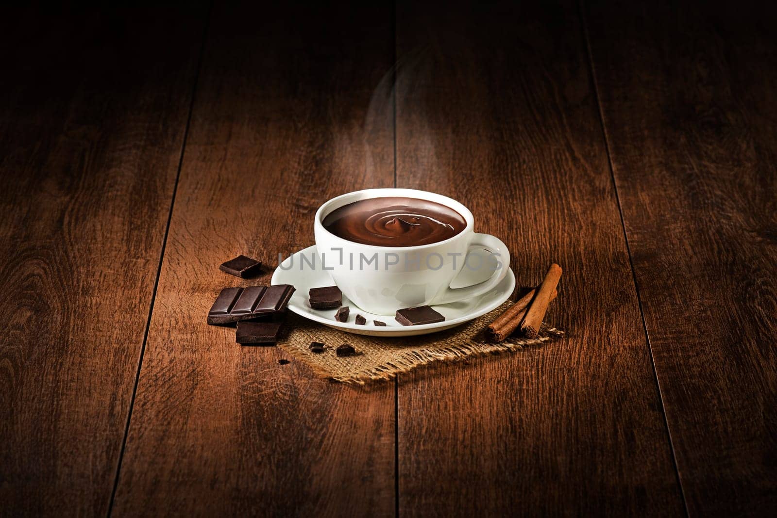 Cup of hot chocolate and cocoa with smoke on wooden background.