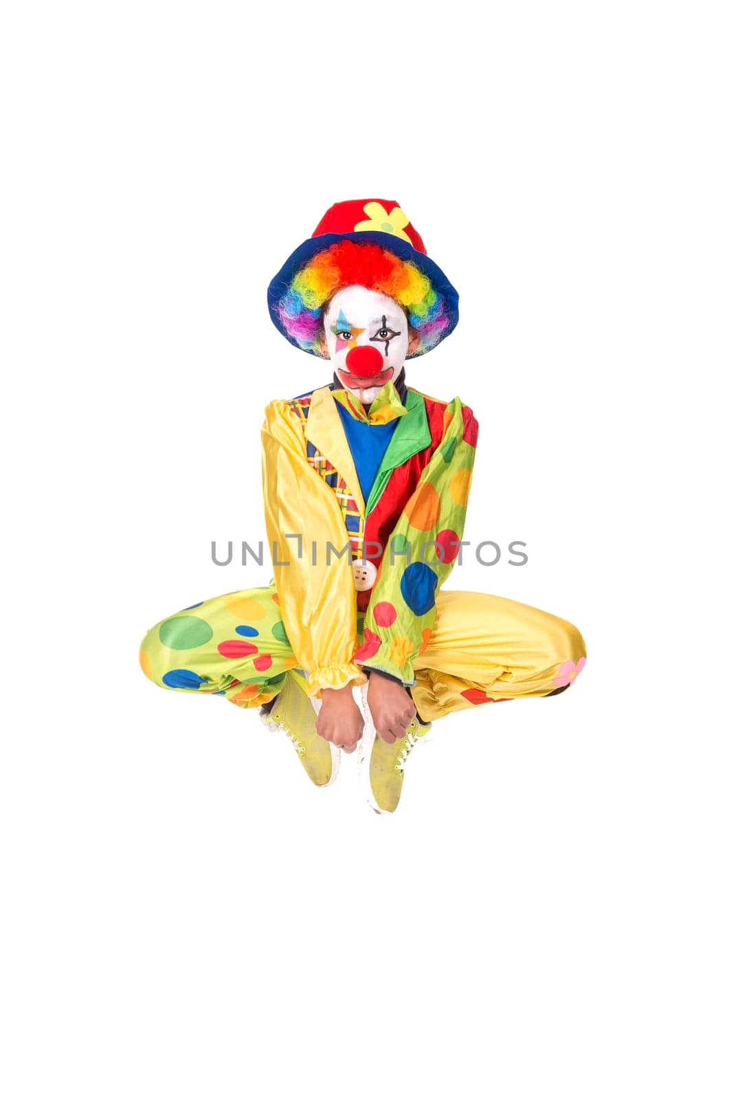 Young girl with clown costume jumping isolated in white