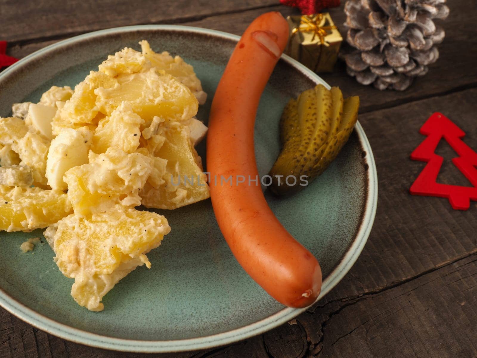 Tasty homemade potato salad with organic sausage and gherkin, traditional Christmas meal