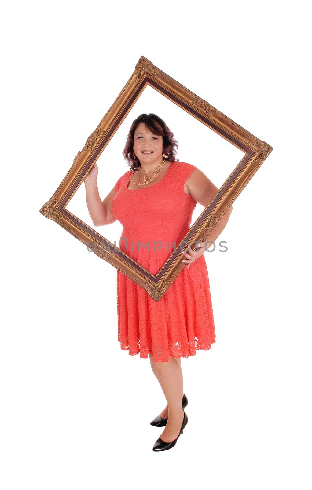 An heavy woman in a red dress standing isolated for white background.holding a old picture frame looking trough.