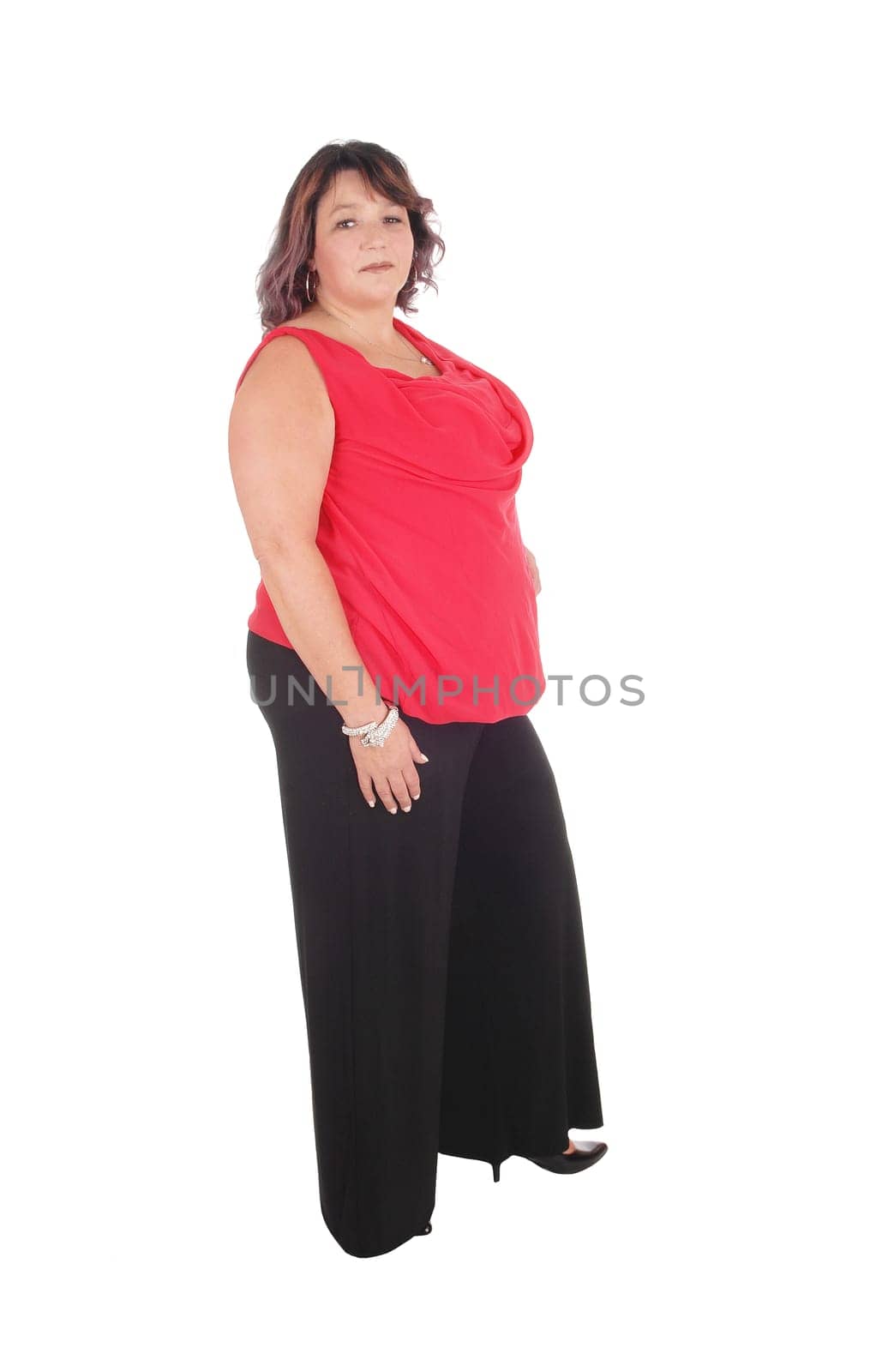 Beautiful full sized woman standing in a red blouse and black trousers.in profile, isolated for white background.