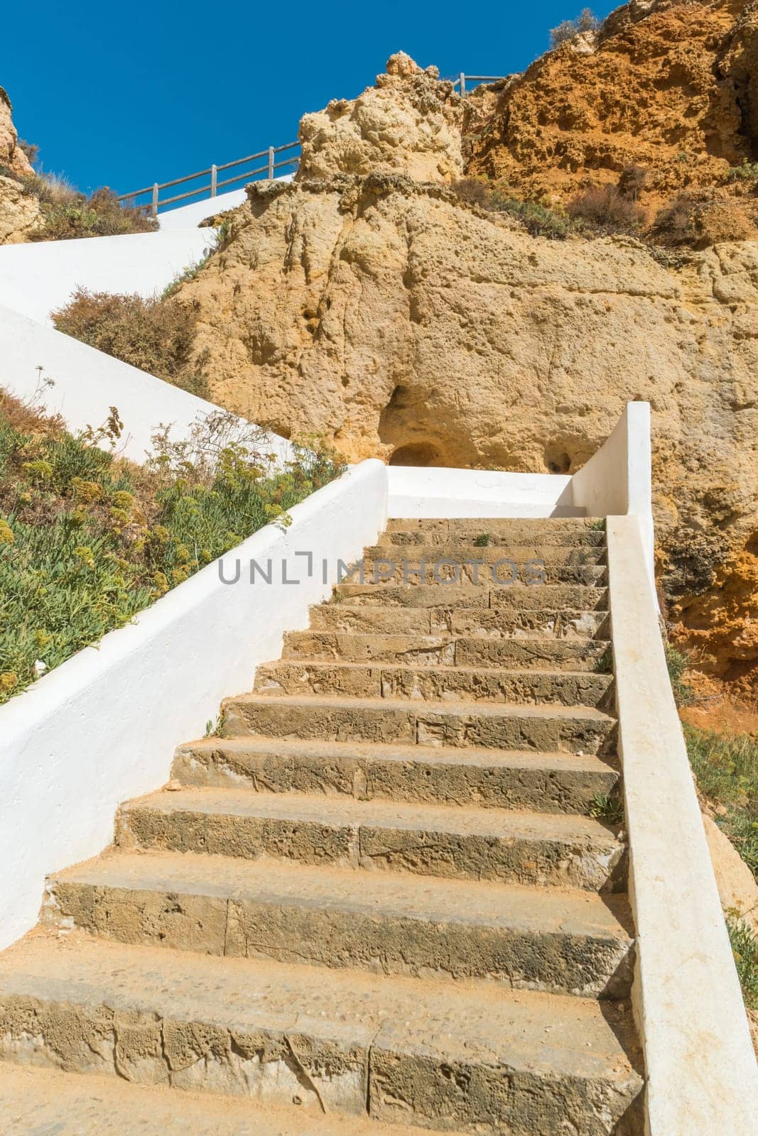 Stairs to a pool of natural sea water between sandstone cliffs at Algar Seco. Carvoeiro Algarve Portugal.