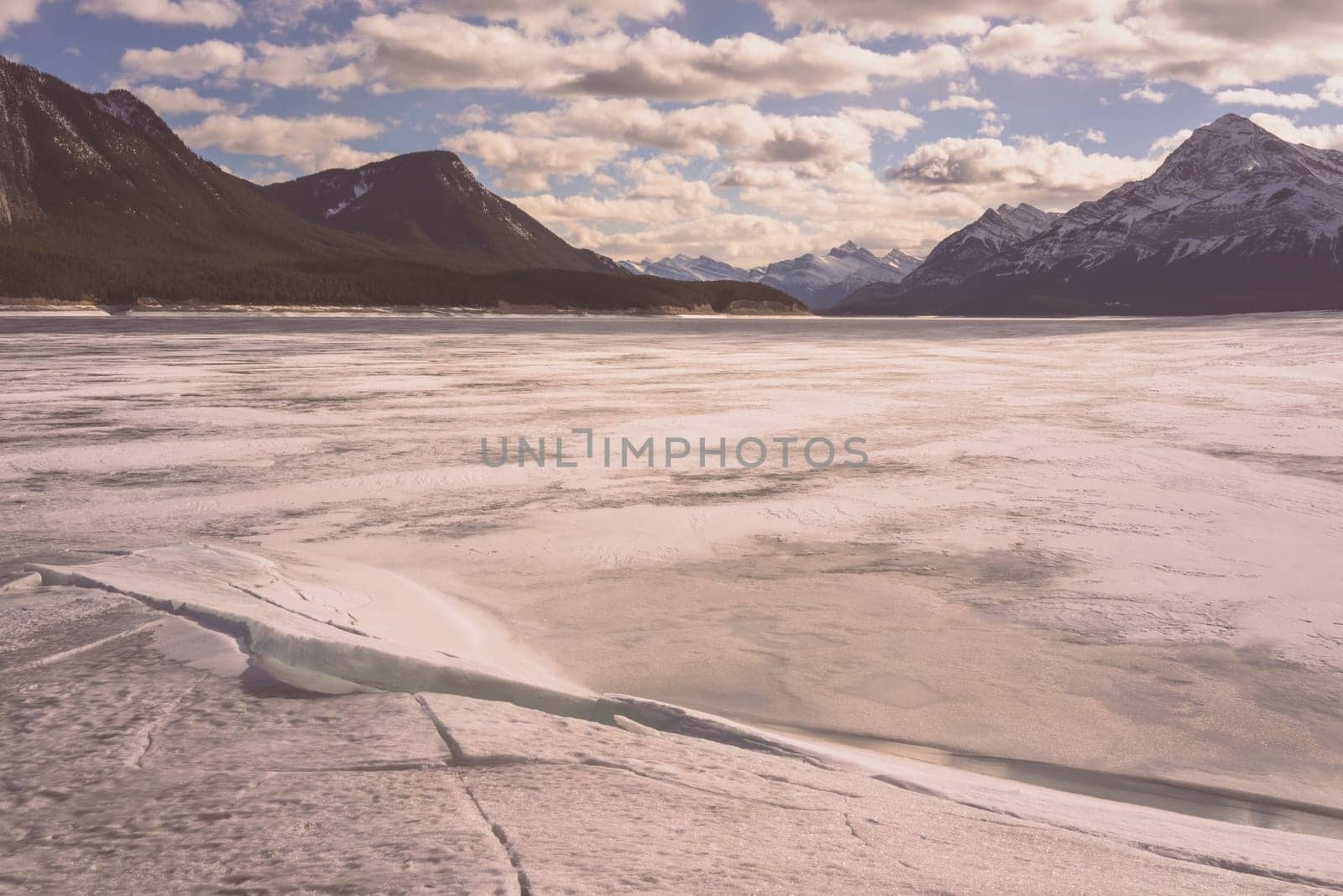 Winter landscape of Abraham Lake with mountains in the background.