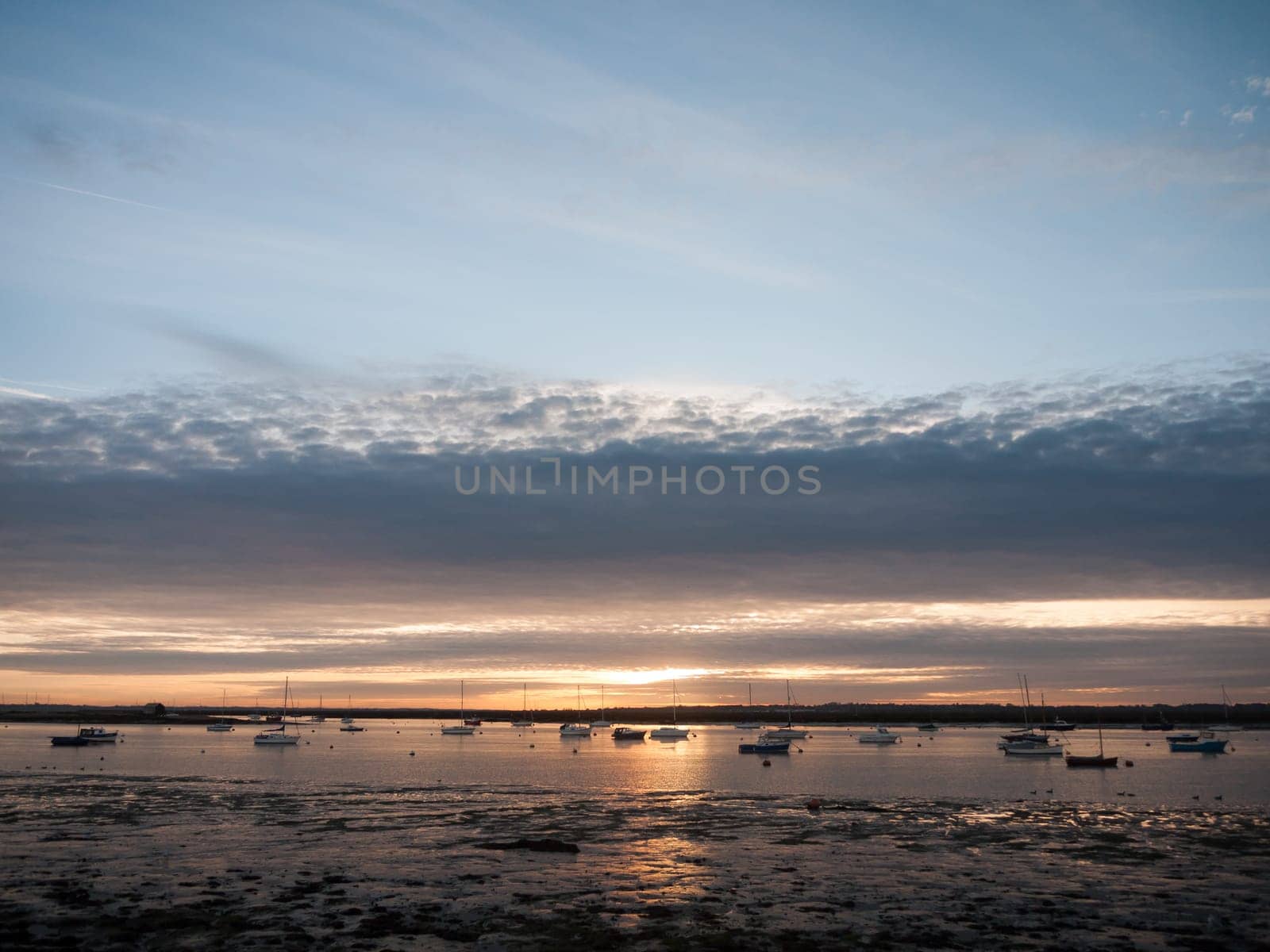 sun set sky dramatic clouds sea front beach harbor marina boats moored landscape  west mersea, essex, england, uk