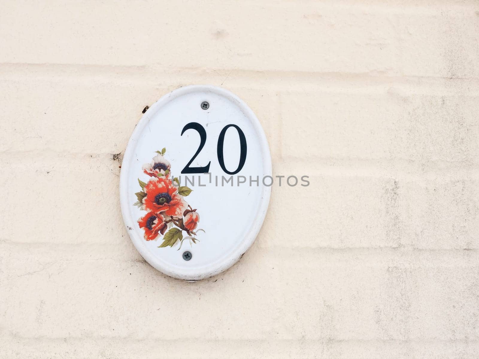 house number plate on outside white wall number 20 flower design  essex  england  uk