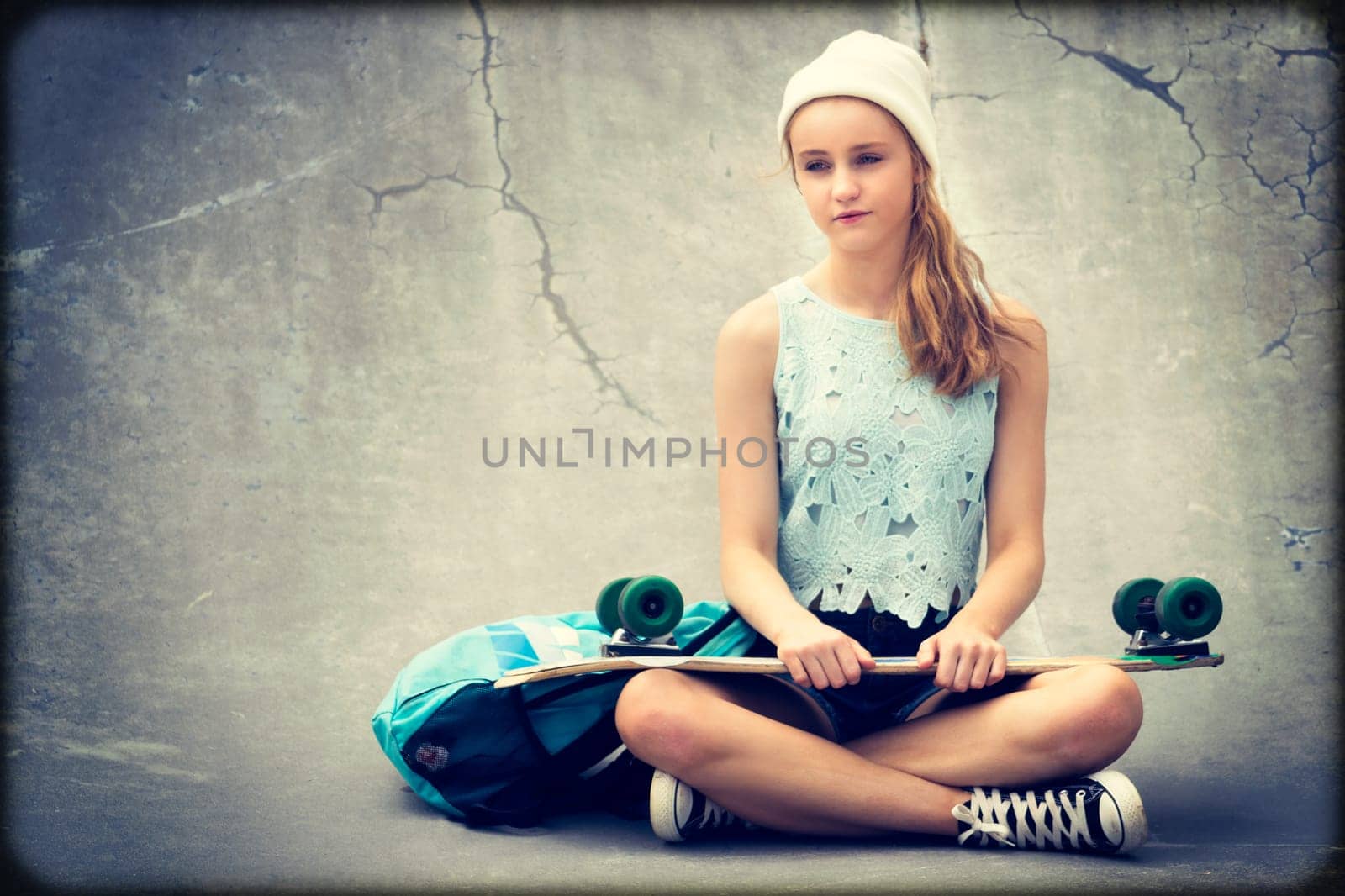 Teenage skater girl holding skateboard