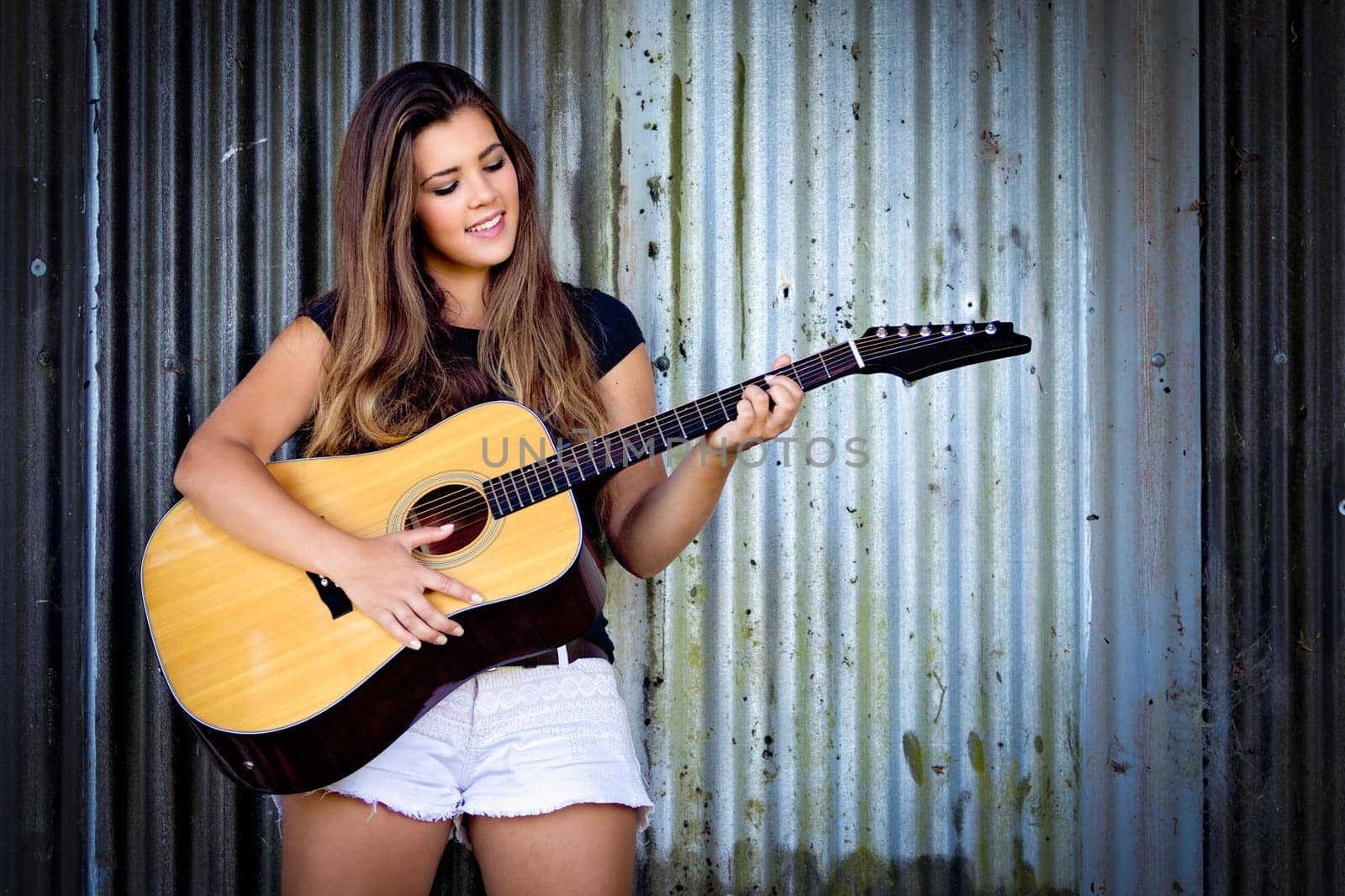 Beautiful smiling girl playing guitar