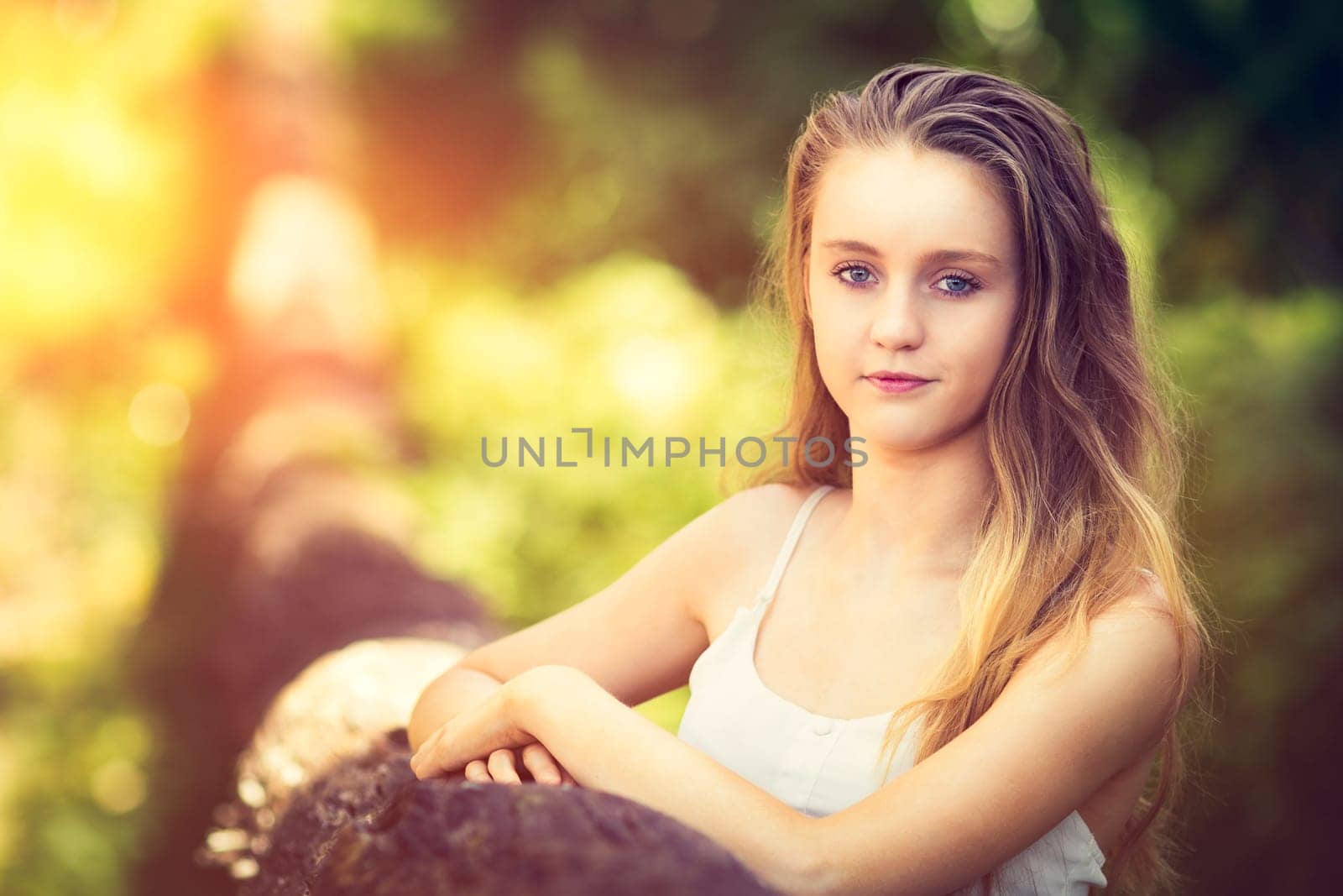 Beautiful young teenage woman by fallen tree