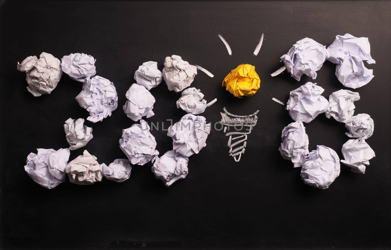 Crumpled paper on a chalkboard with the number 2018, New Years creativity concept