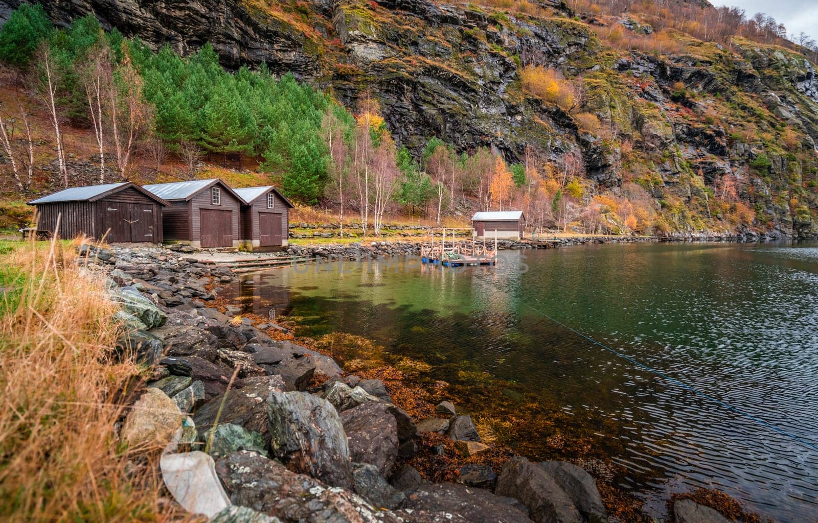 Three wooden huts on the shore of a fiord in a small village Flam, Norway