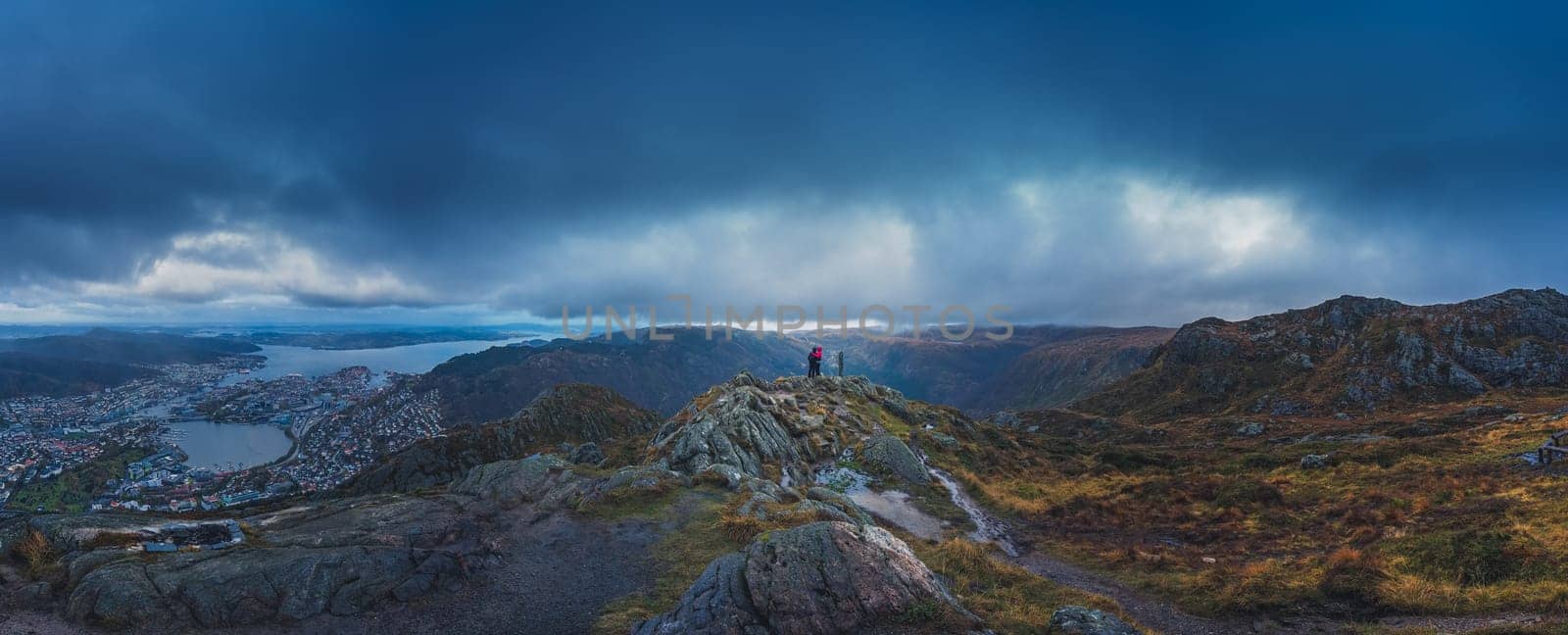 Unidentifiable tourists standing on the top of mount Ulriken in Bergen in loving embrace, Norway