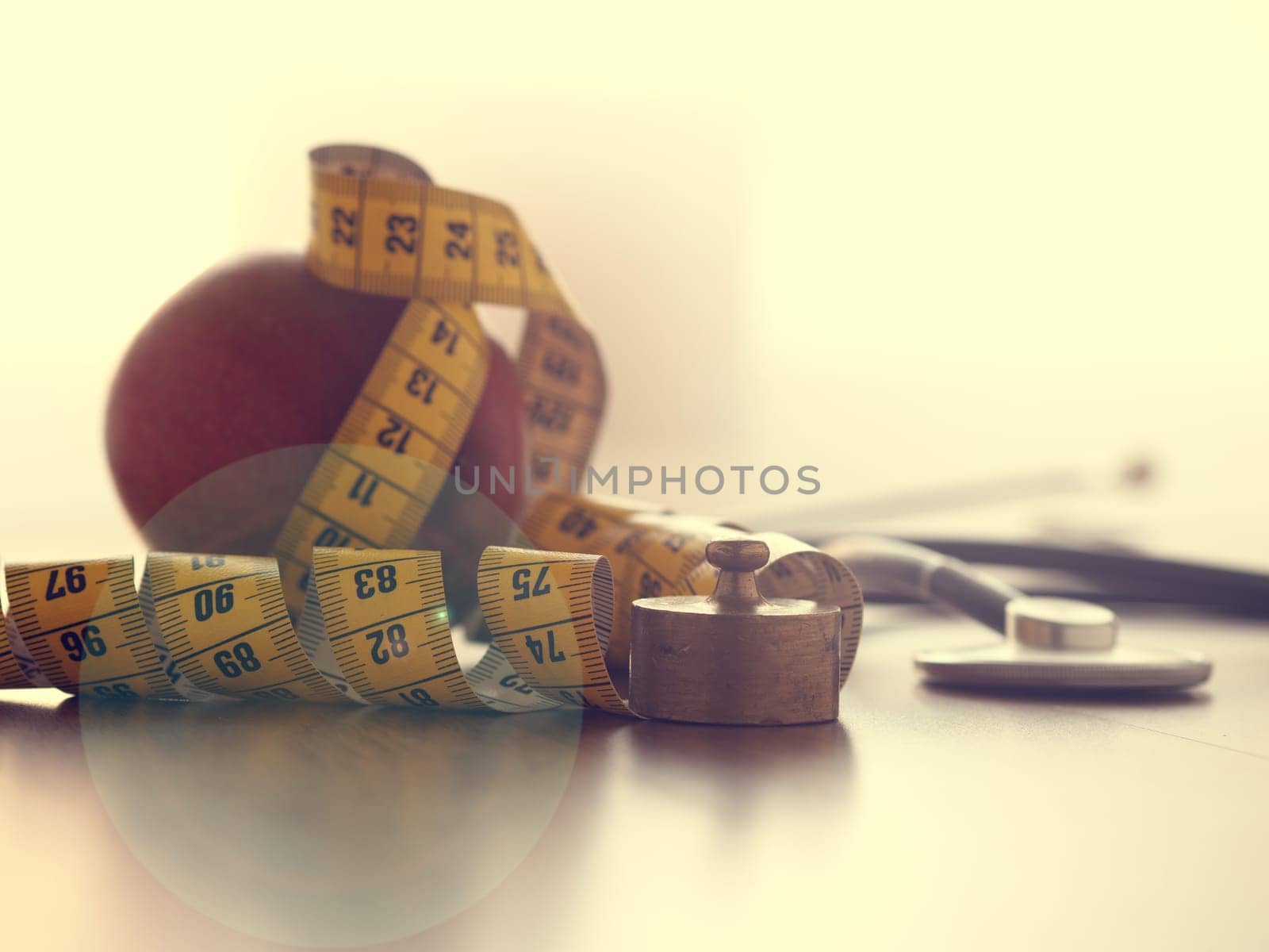 Healthy food concept with an organic apple and a stethoscope on a wooden table