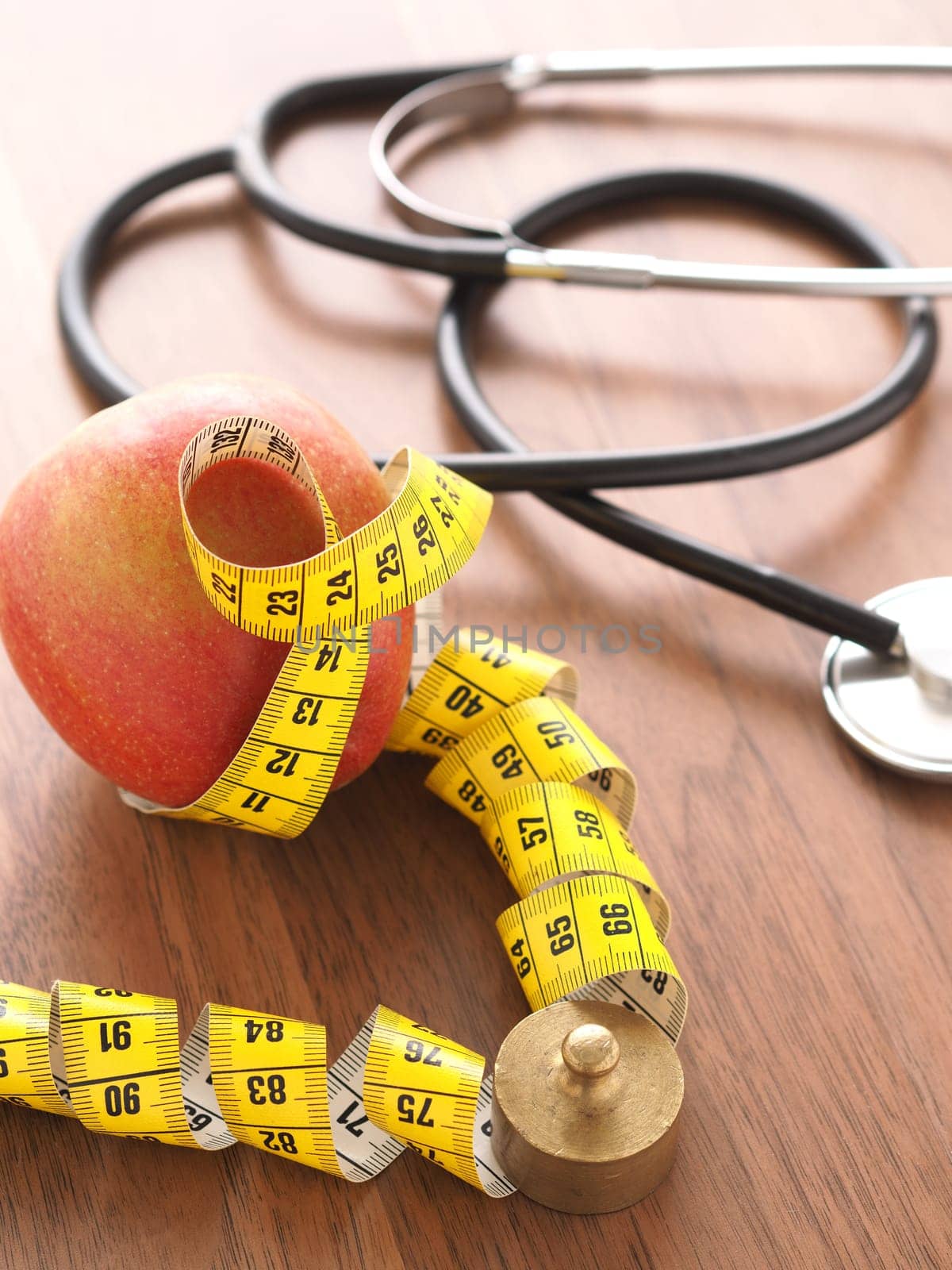 Healthy food concept with an organic apple and a stethoscope on a wooden table