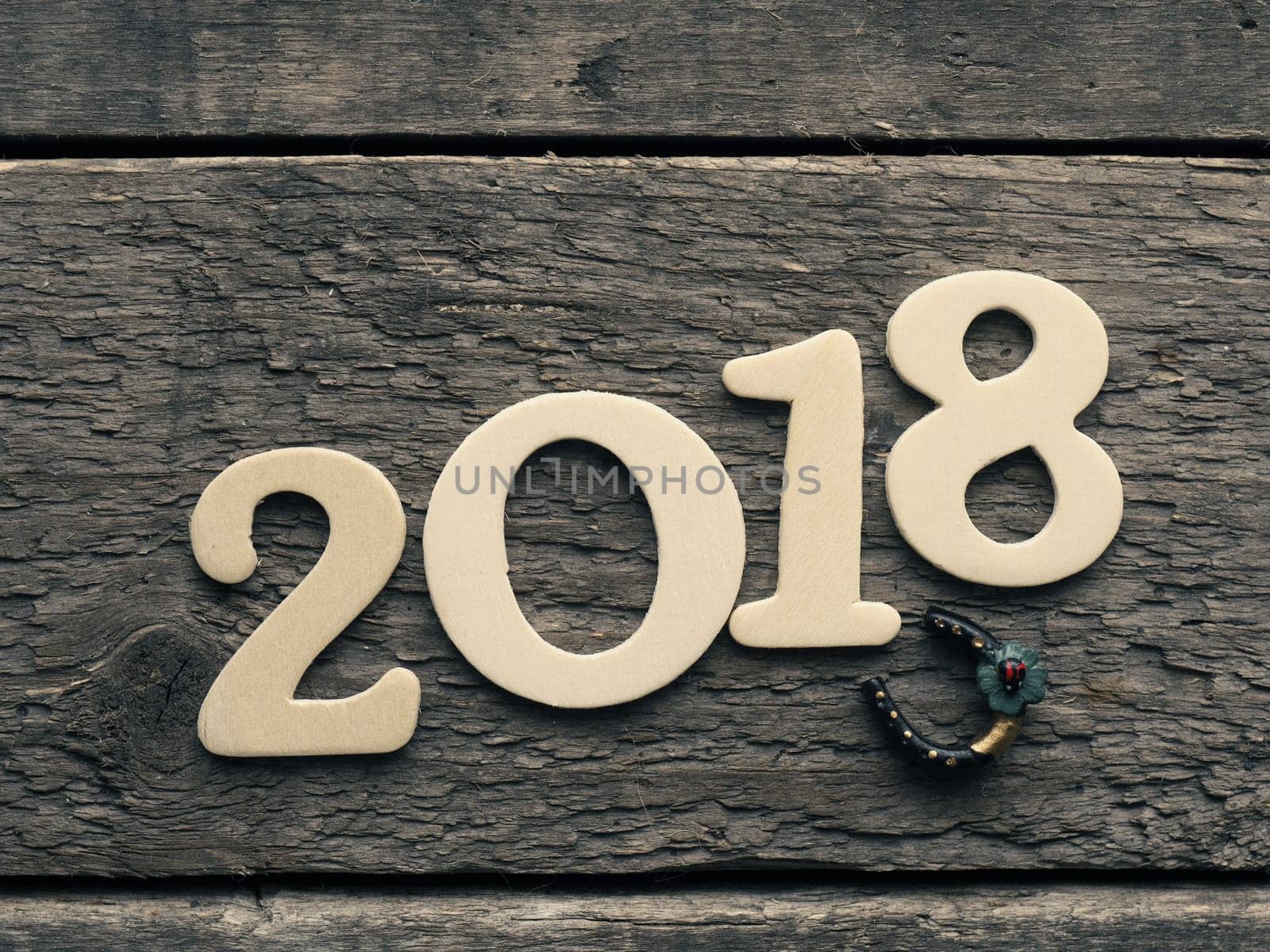 New Year 2018 with a horse shoe on a rustic wooden plank, Happy New Year and Good luck
