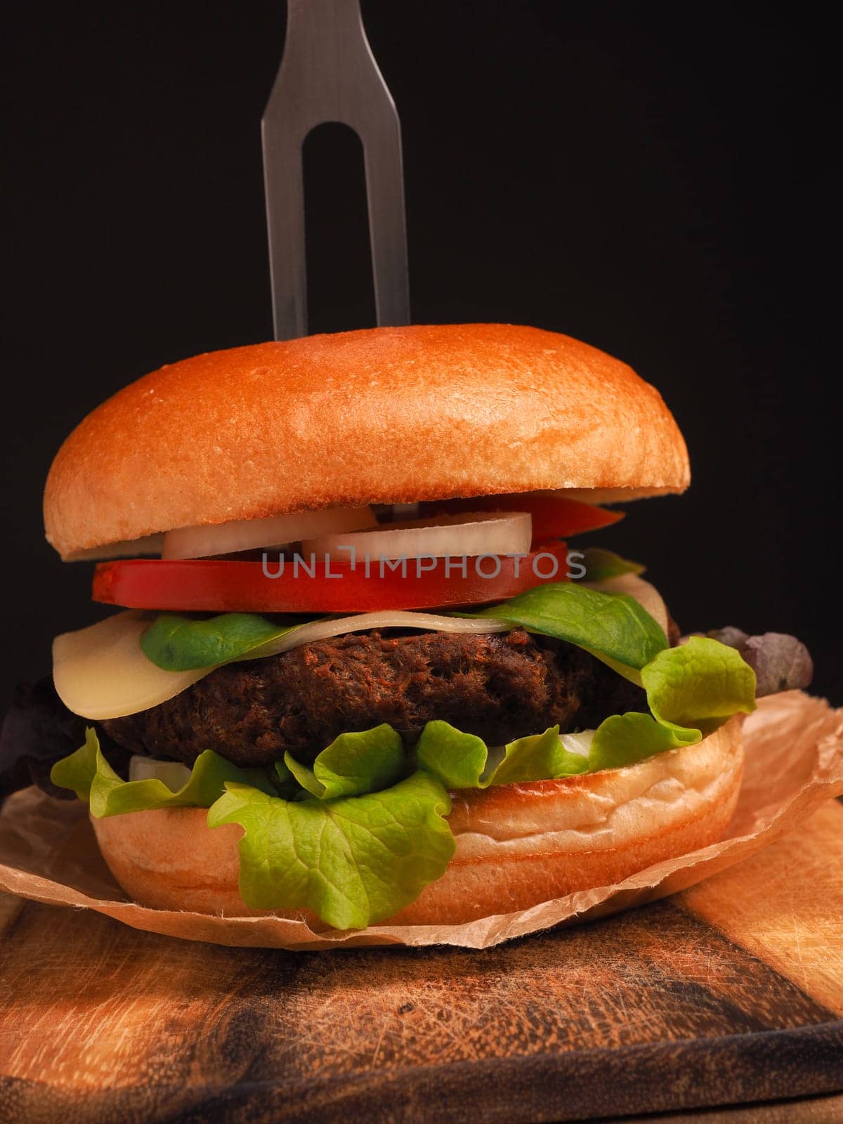 Tasty homemade burger with organic beef on a rustic wooden kitchen table, healthy food concept