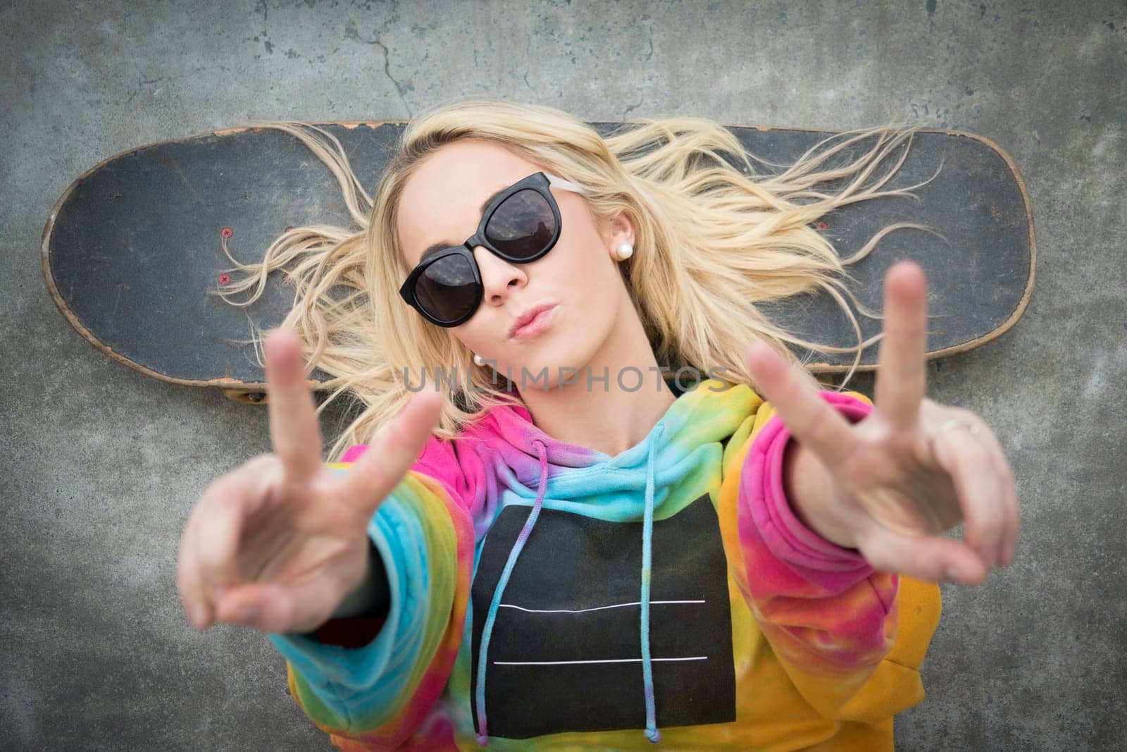 Blond teen skater girl giving peace sign
