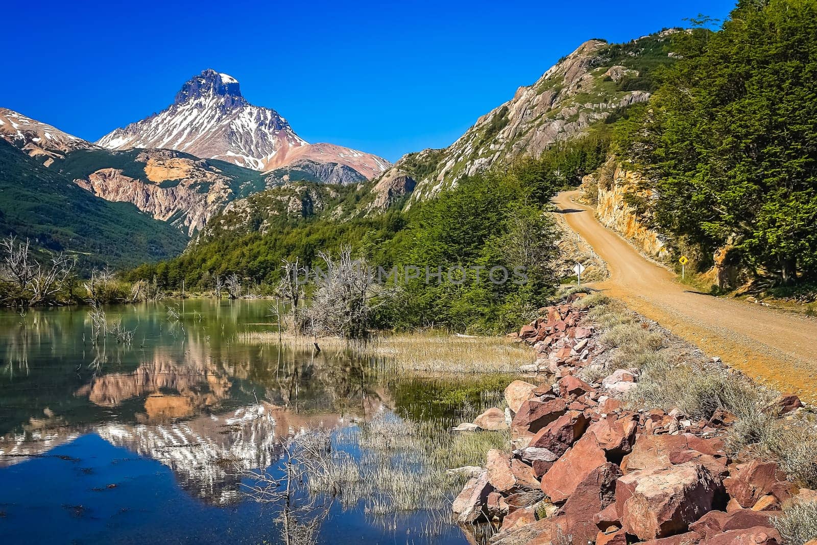 Gravel Carretera Austral road and reflection of mount Cerro Castillo, Patagonia, Chile
