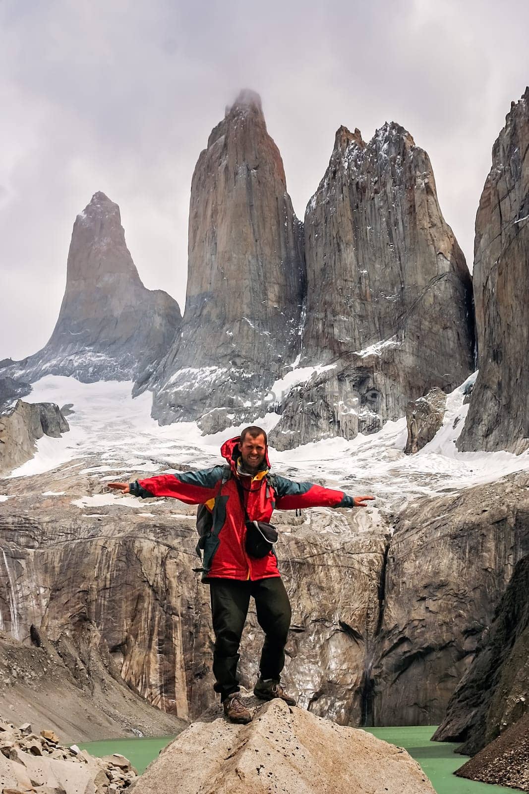 Man standing on the rock in front of the stunning Torres del Paine peaks, Patagonia, southern Chile, South America