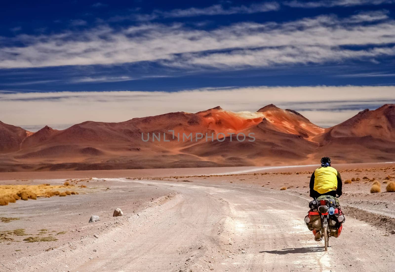 Man cycling on the corrugated sandy road through Altiplano in Bolivia