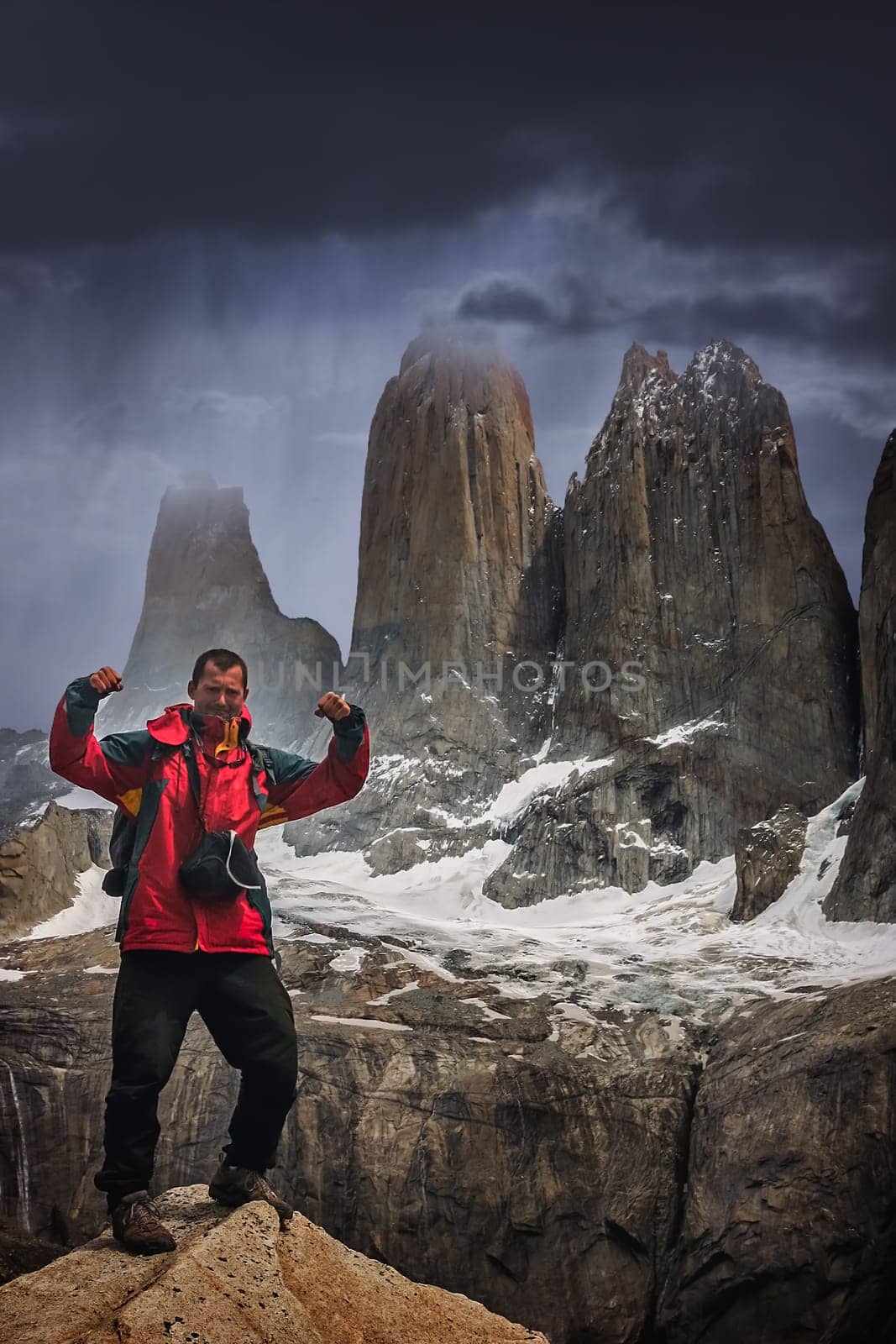 Man standing on the rock in front of the stunning Torres del Paine peaks, Patagonia, southern Chile, South America