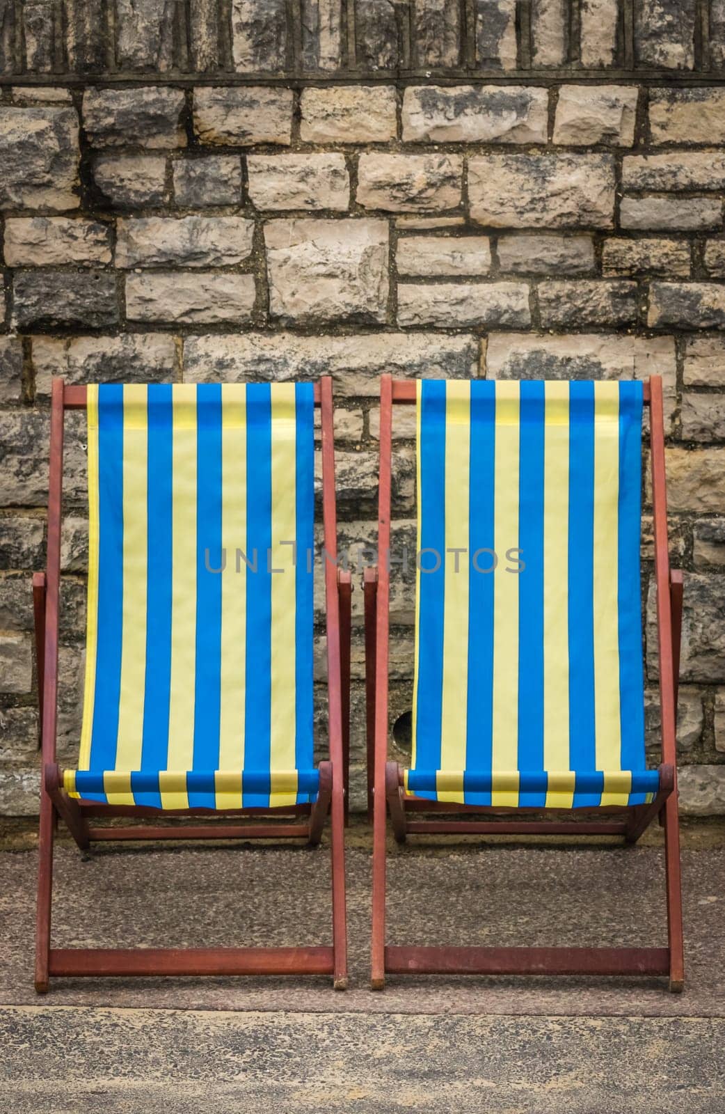 Empty yellow and blue striped deckchairs, Bournemouth, England
