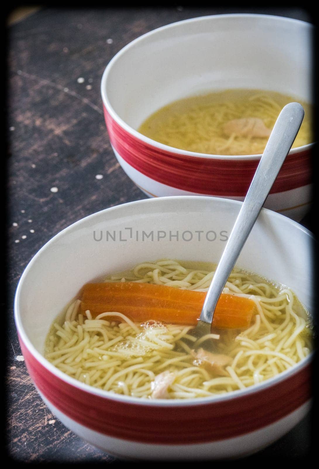 Chicken broth soup in a bowl on a table