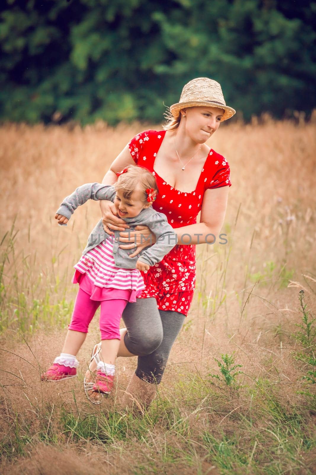 Mother and daughter playing together on a meadow