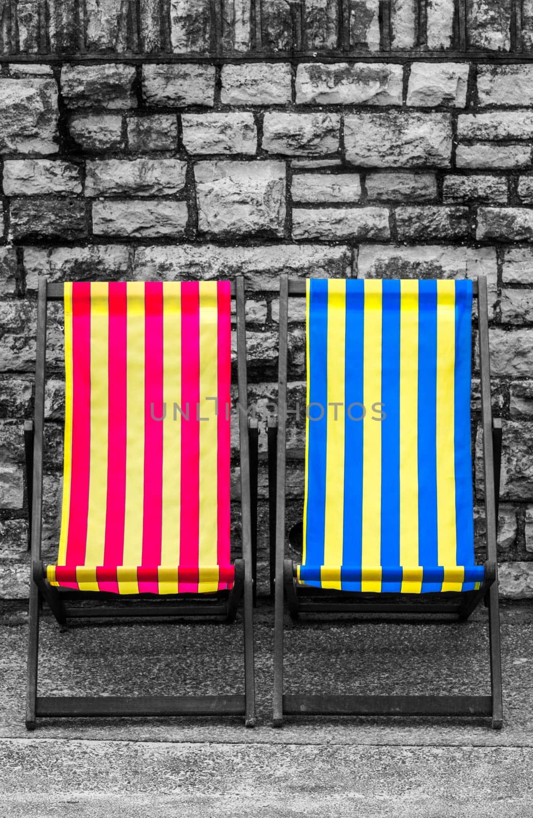 Empty red, blue and yellow striped deckchairs, Bournemouth, England