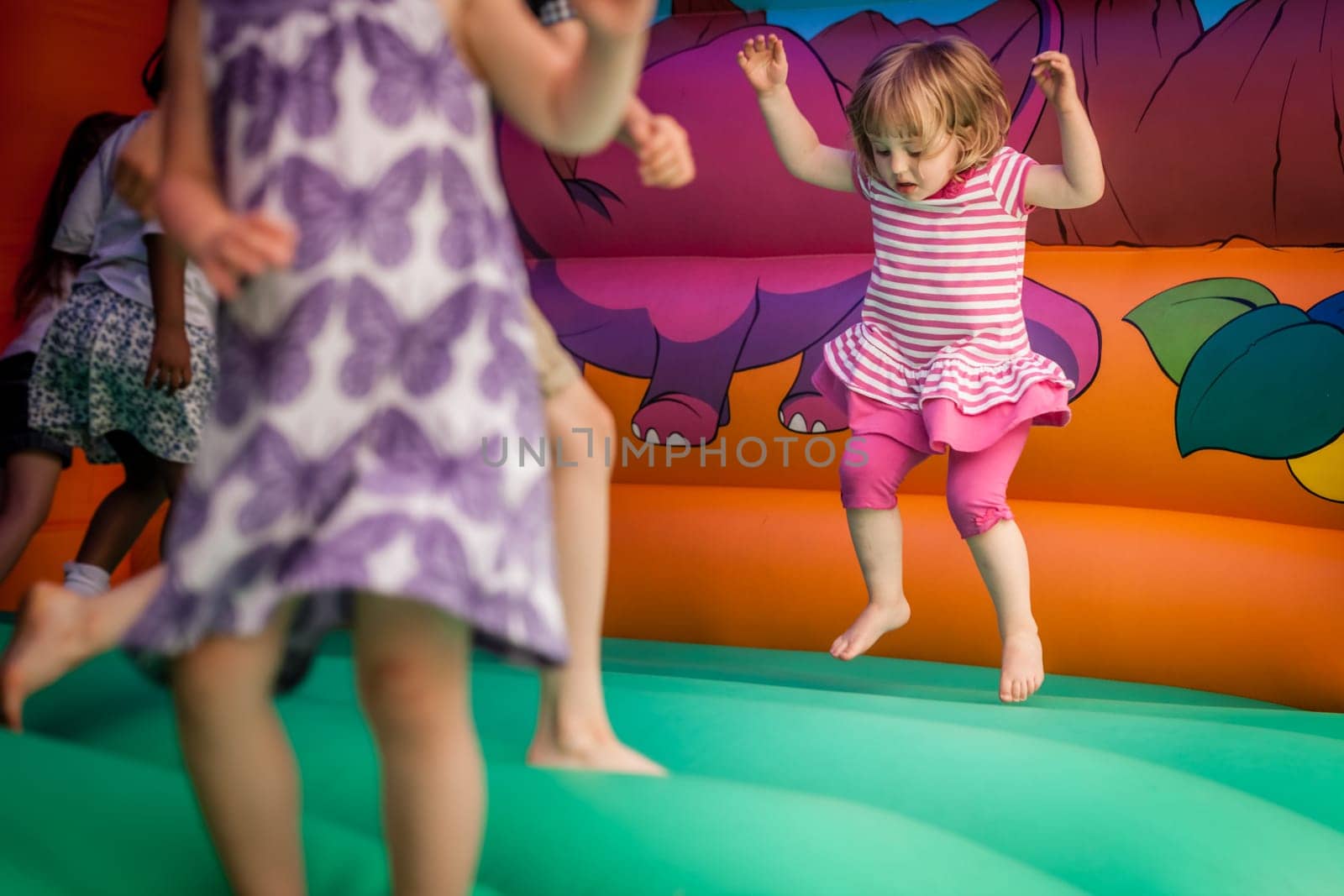 Cute little girl jumping inside the inflatable bouncy castle