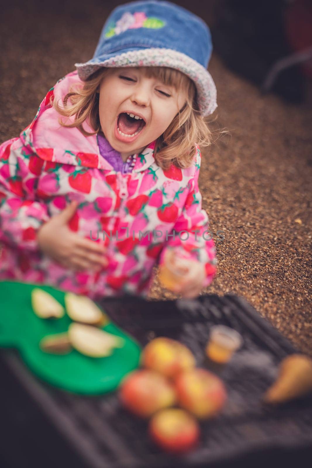 Portrait of a cute little girl tasting fresh organic apple juice at a local farmers market